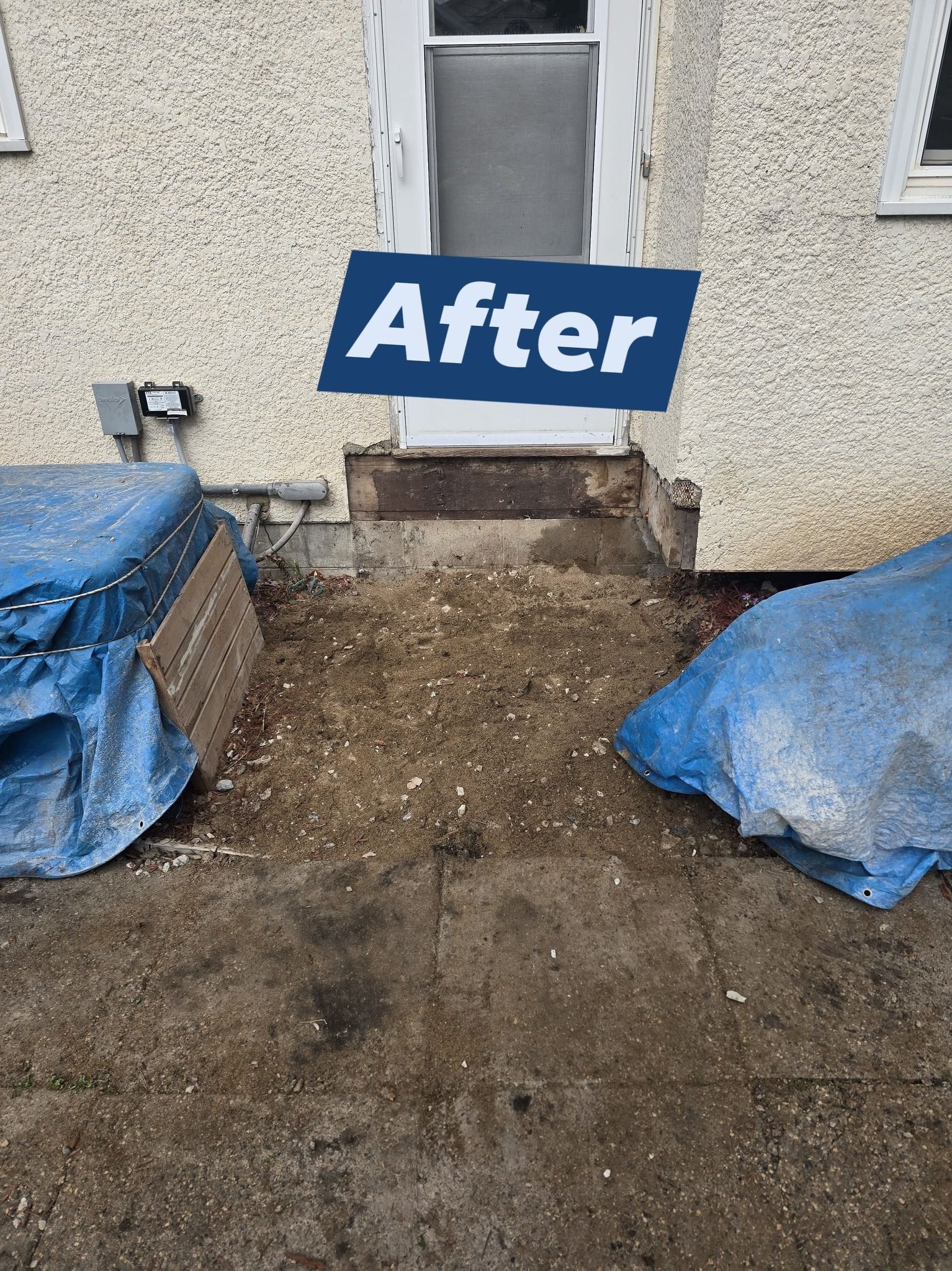 Back door entrance after renovation with exposed base and covered items.