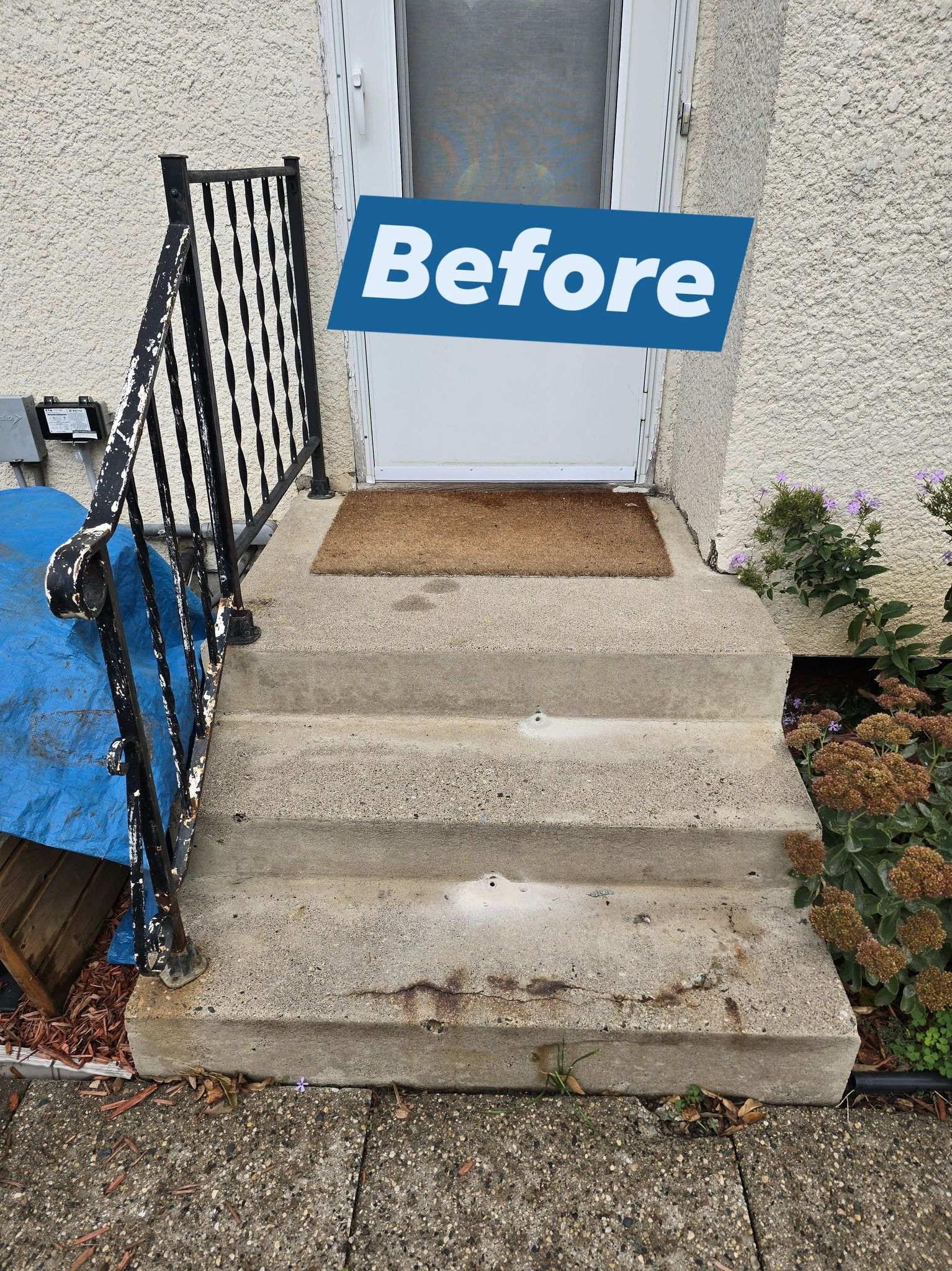 Concrete steps leading to a white door with 
