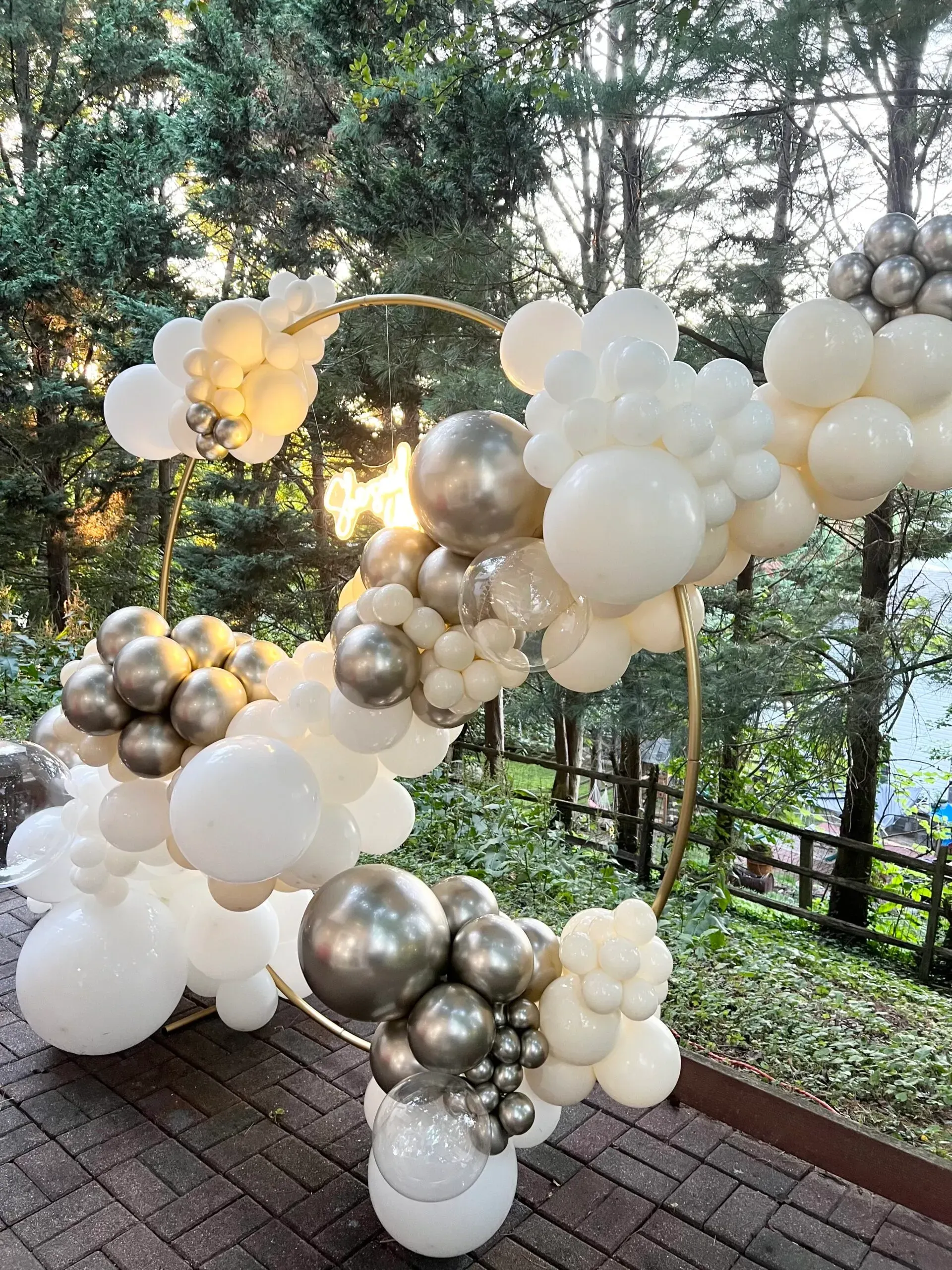 A bunch of balloons are sitting on top of a brick floor.