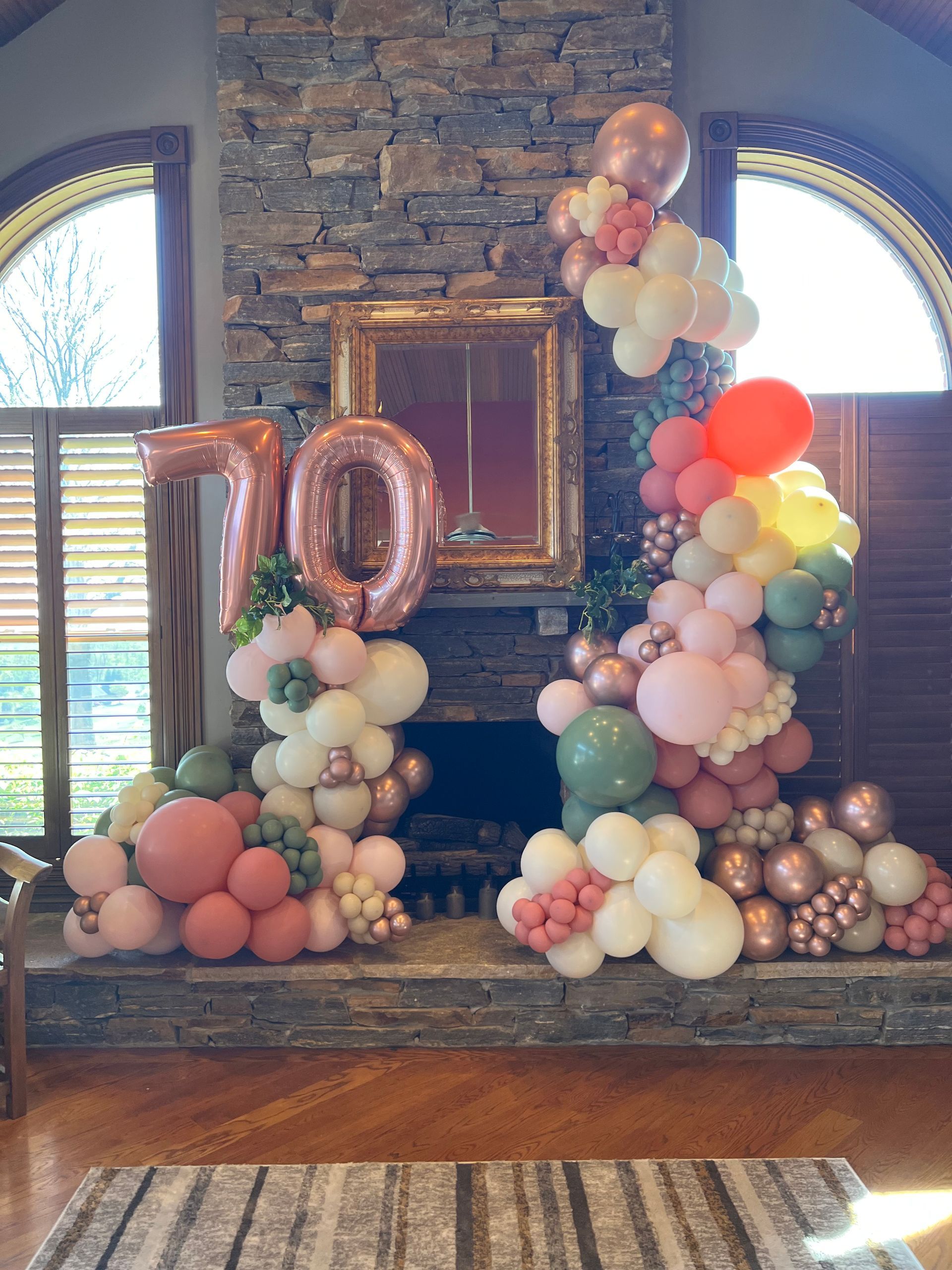 A fireplace decorated with balloons for a 70th birthday