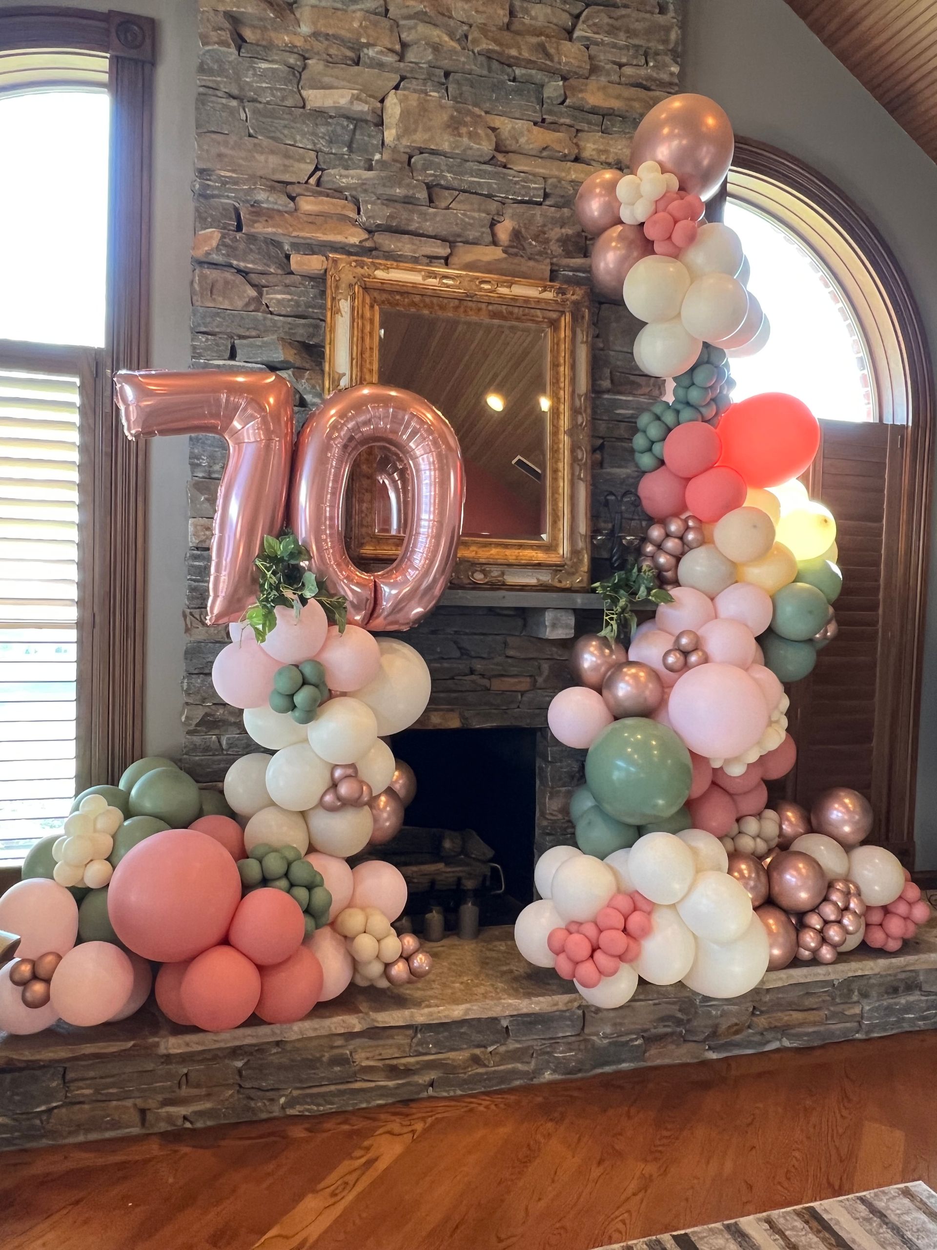 A fireplace decorated with balloons for a 70th birthday.