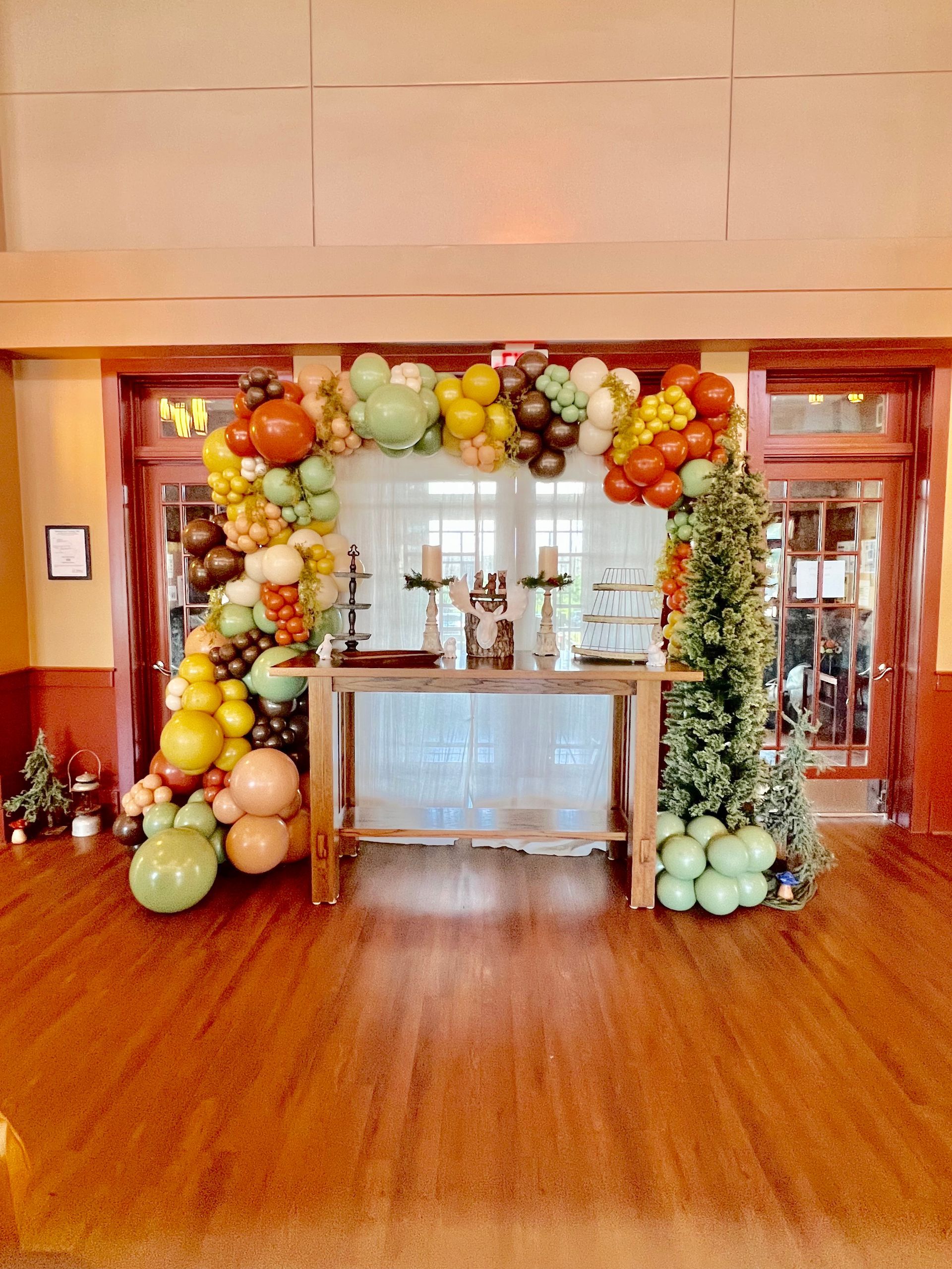 A room with a table and a bunch of balloons on it.