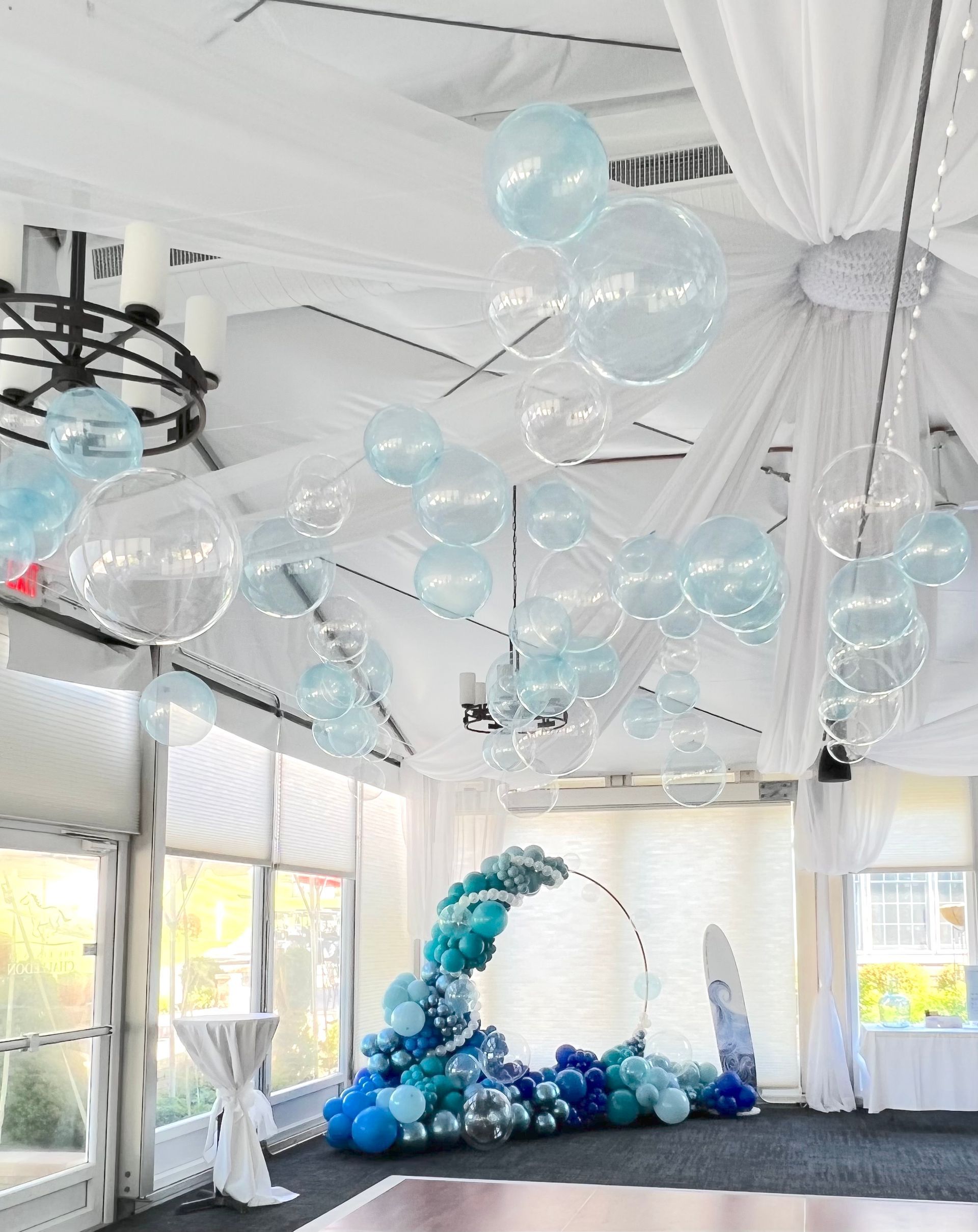 A room with balloons hanging from the ceiling and a dance floor.