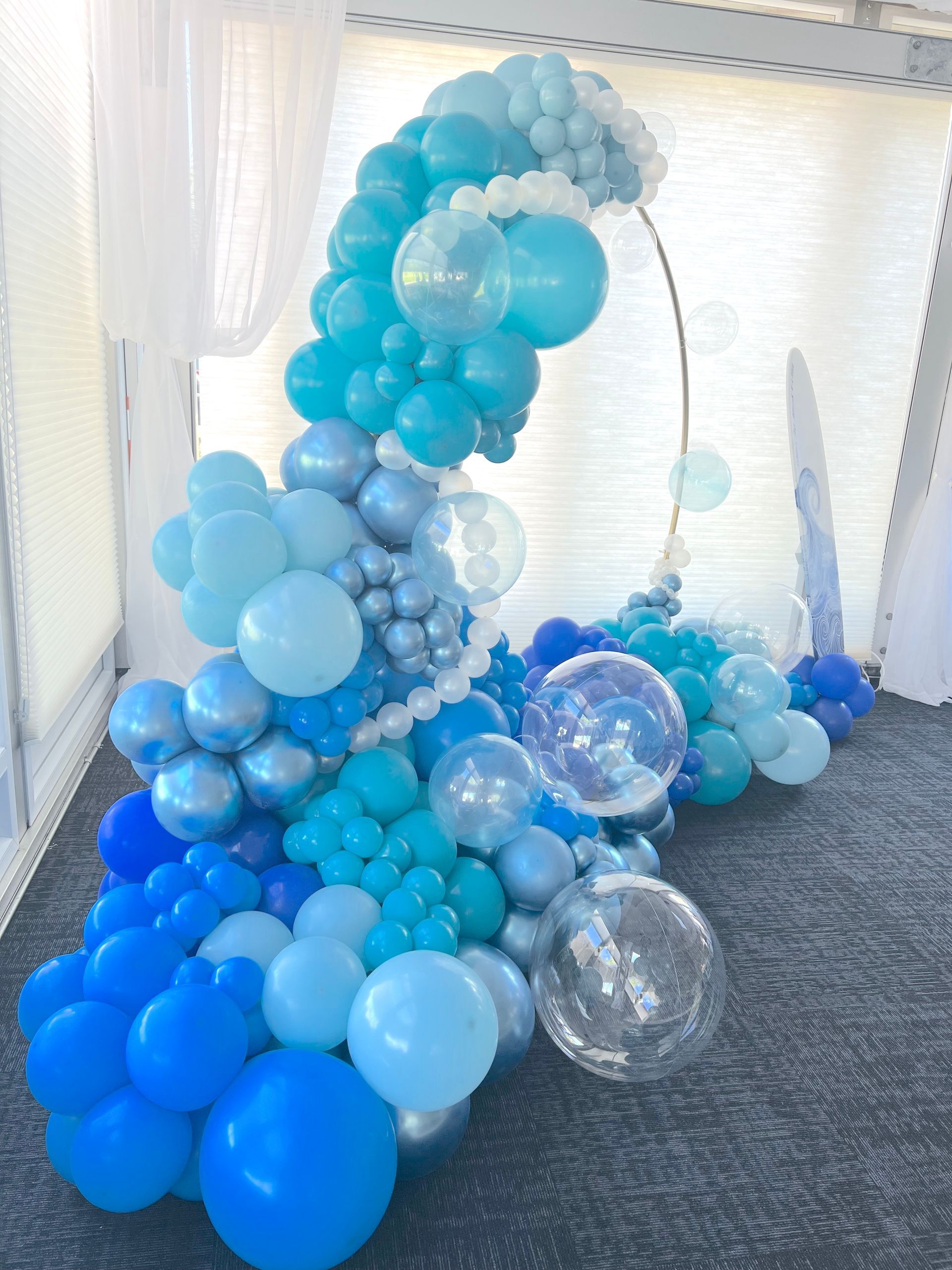 A bunch of blue balloons are sitting on the floor in a room.
