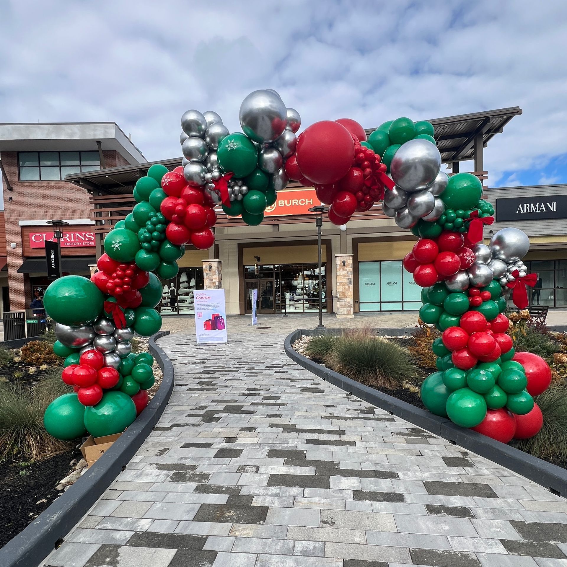 Christmas themed balloon arch in green, red and silver.
