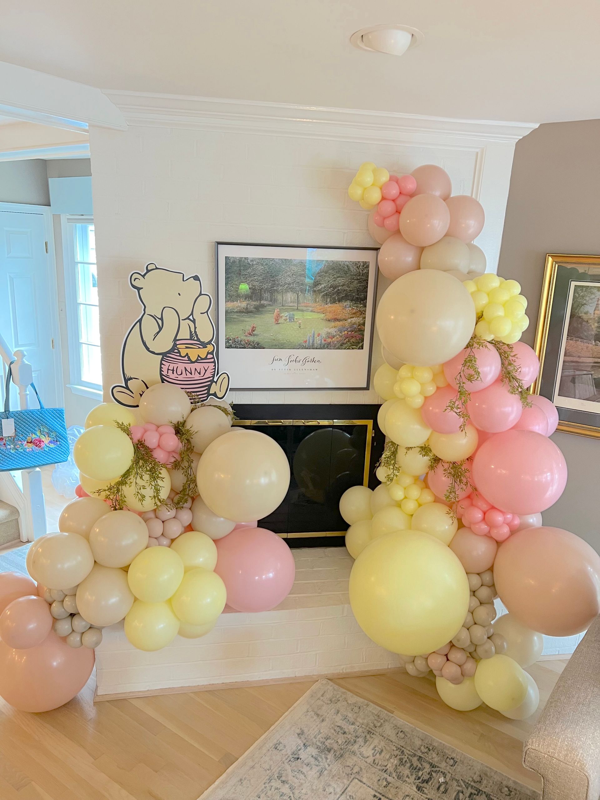 A fireplace decorated with balloons and a picture of winnie the pooh.