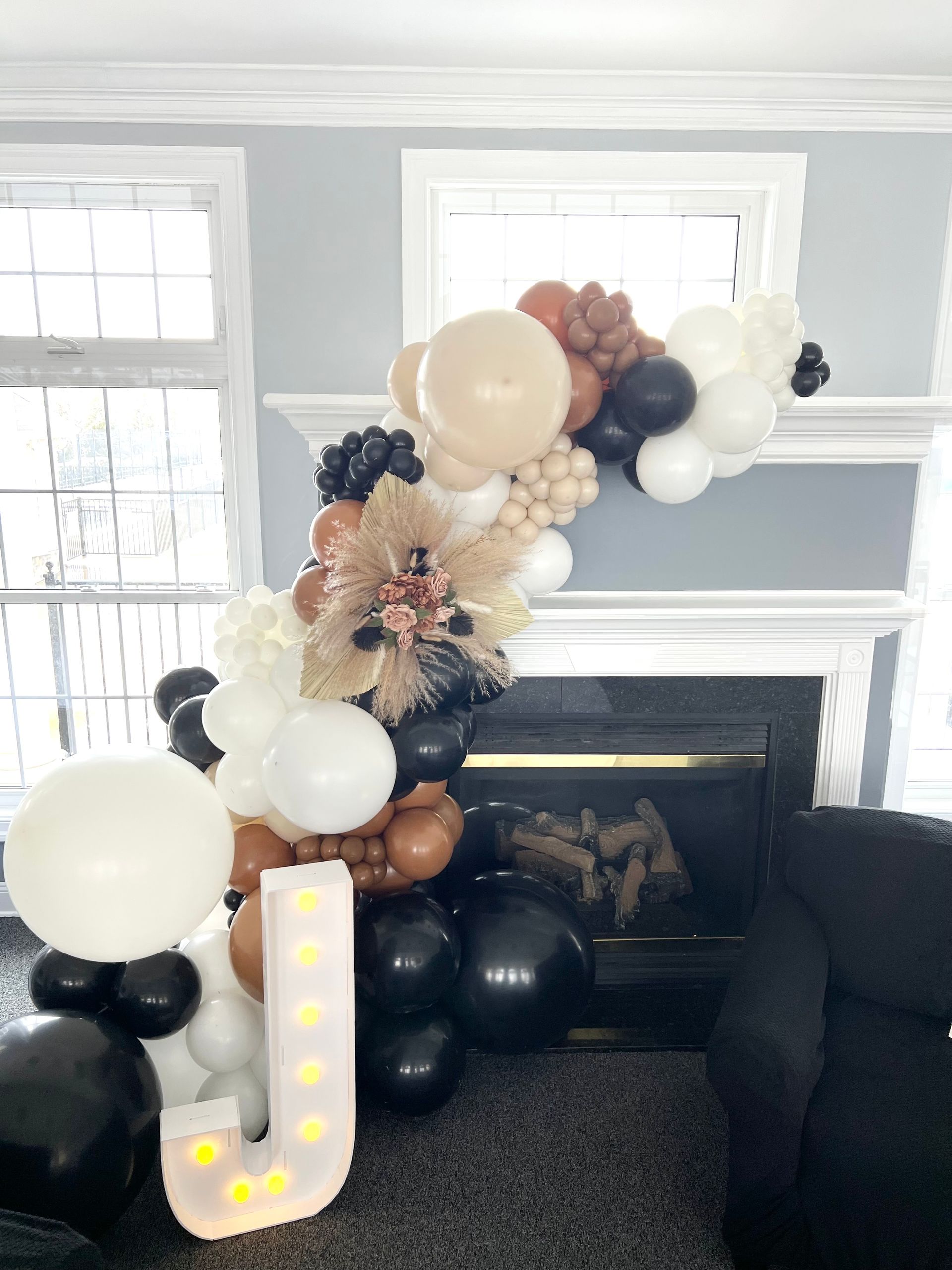 A living room decorated with balloons and a letter j.