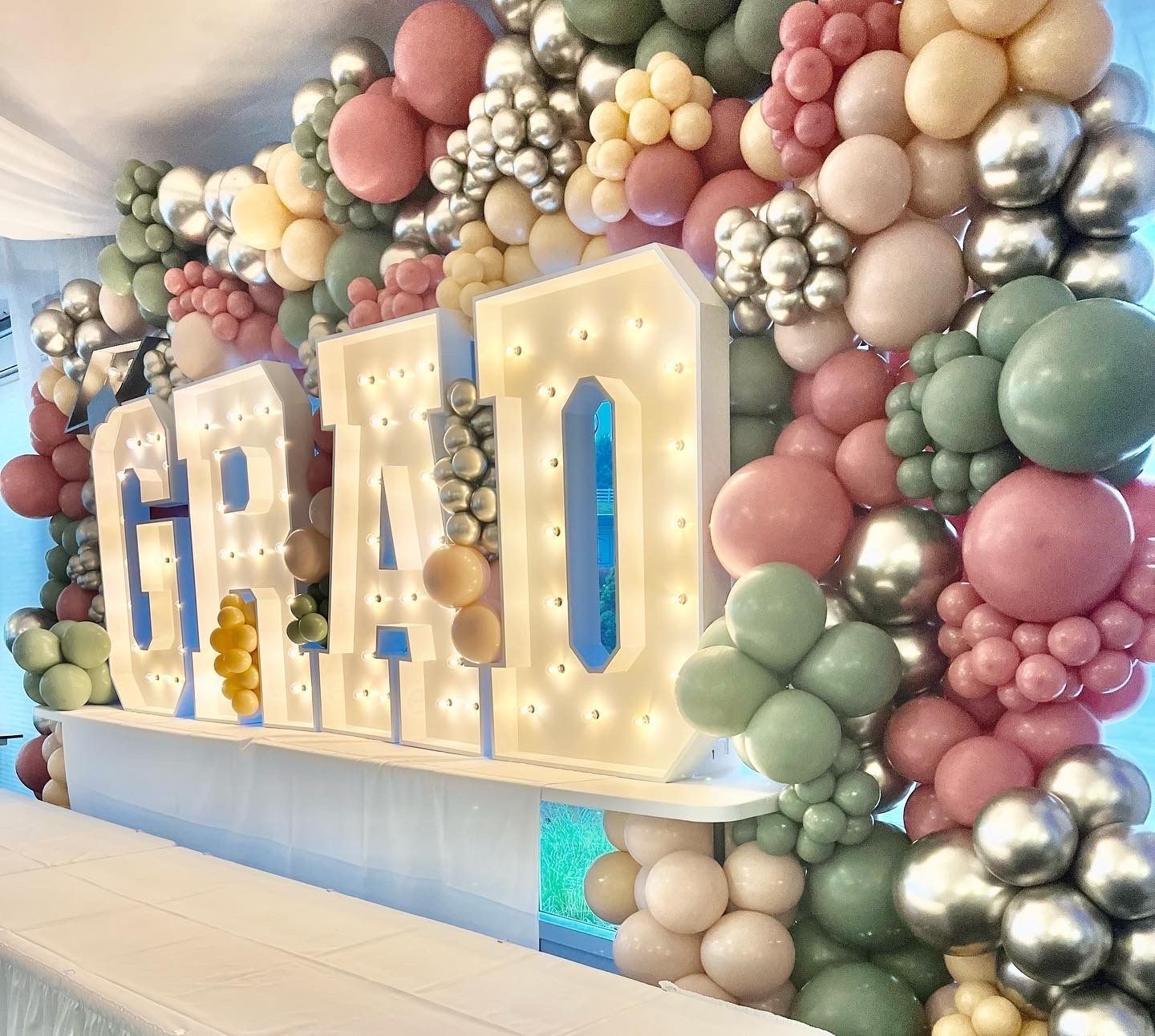 The word graduation is surrounded by balloons and lights