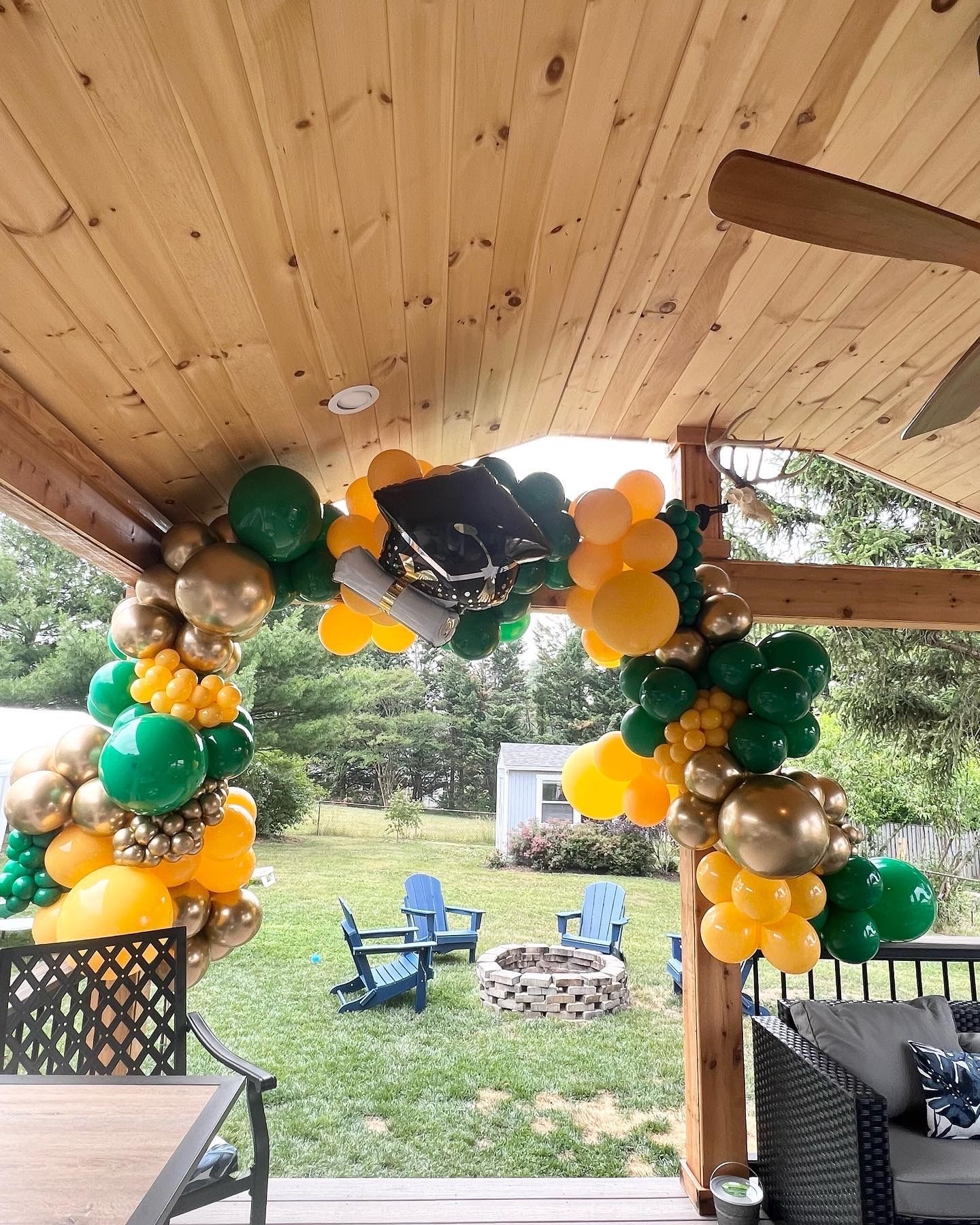 A patio with balloons and a graduation cap on it.