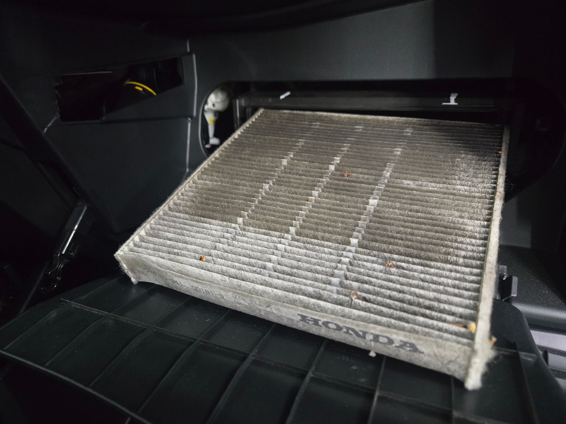 Dirty Honda cabin air filter inside a vehicle.