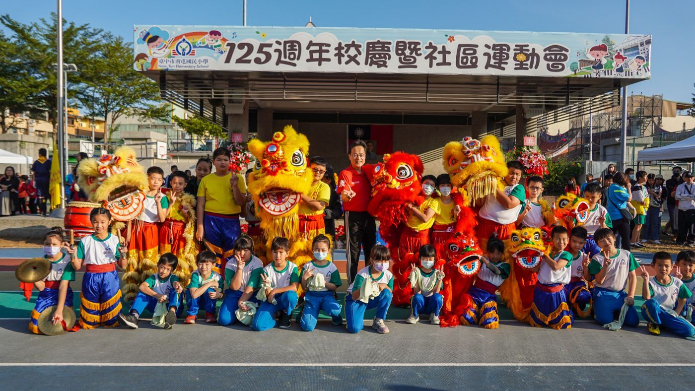 一群孩子正在與舞獅者合照。