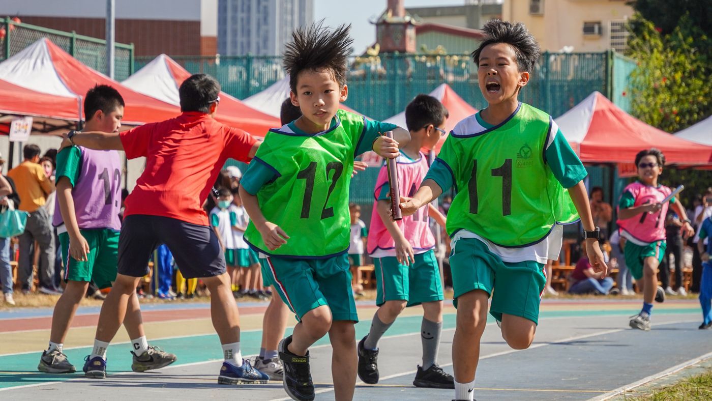 一群小男孩正在跑道上奔跑。