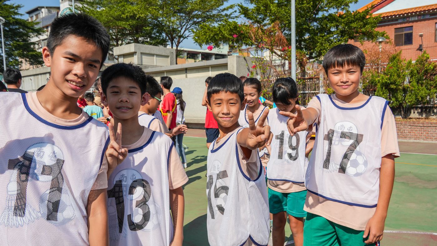 一群小男孩正在籃球場上擺姿勢拍照。