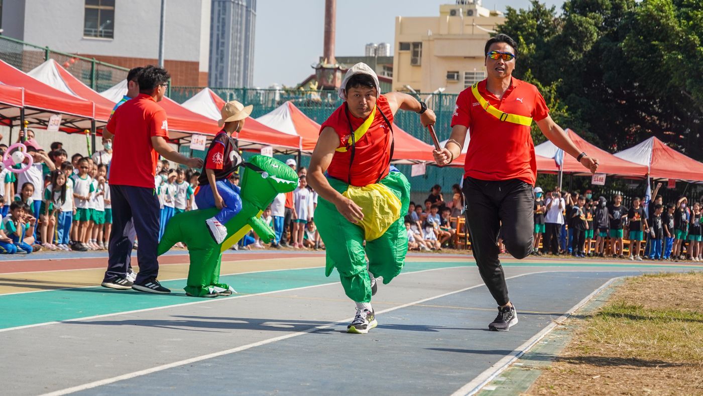一群人打扮成恐龍在跑道上奔跑。