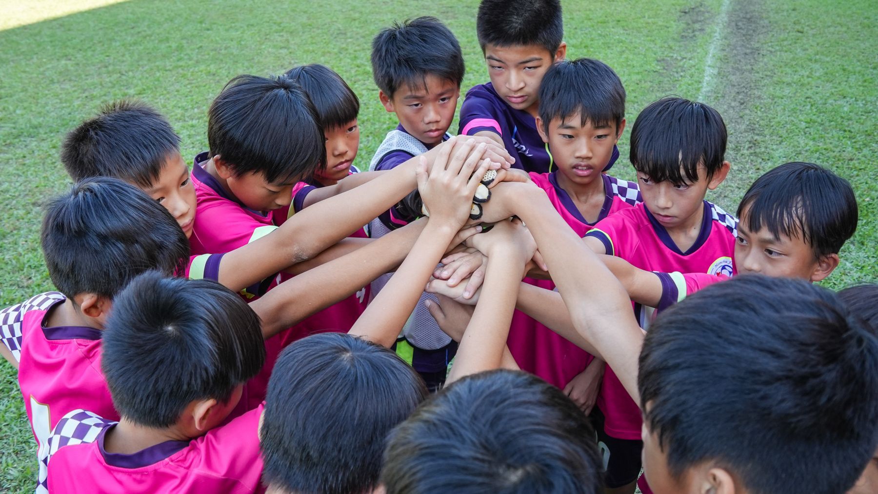 一群小男孩正把手擠在一起。