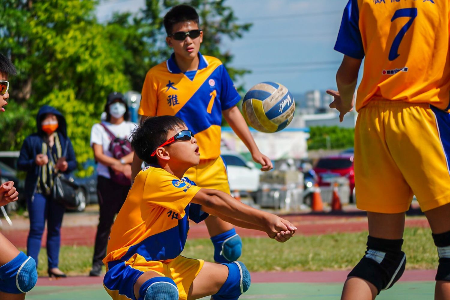一群小男孩正在操場上打排球。
