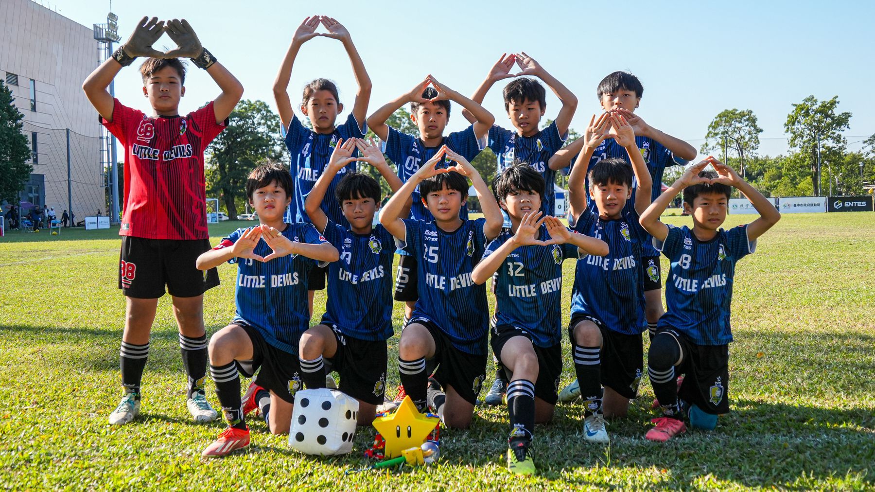 一群小男孩正在足球場上擺姿勢拍照。