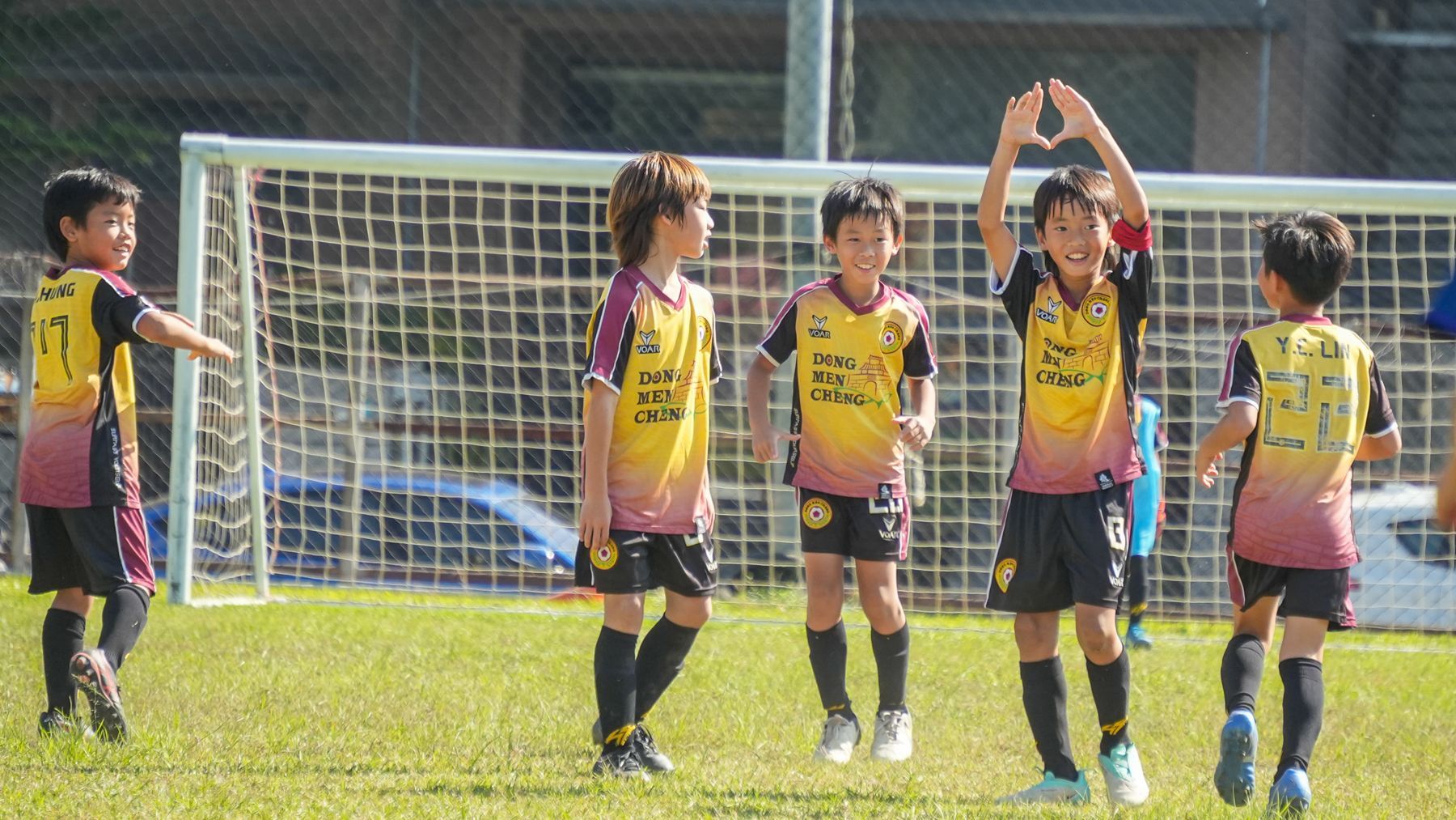 一群小男孩正在操場上踢足球。