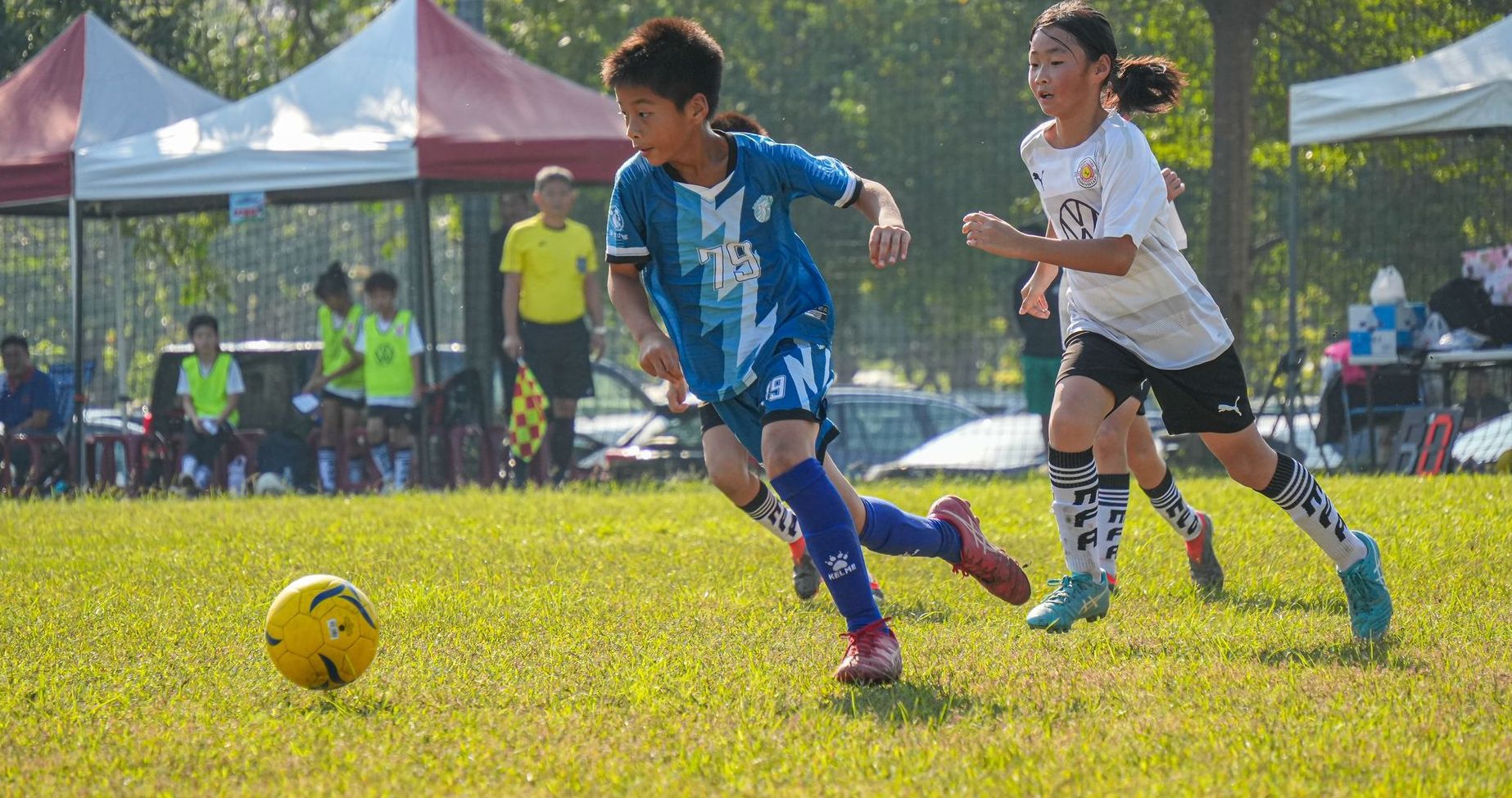 一群小男孩正在操場上踢足球。
