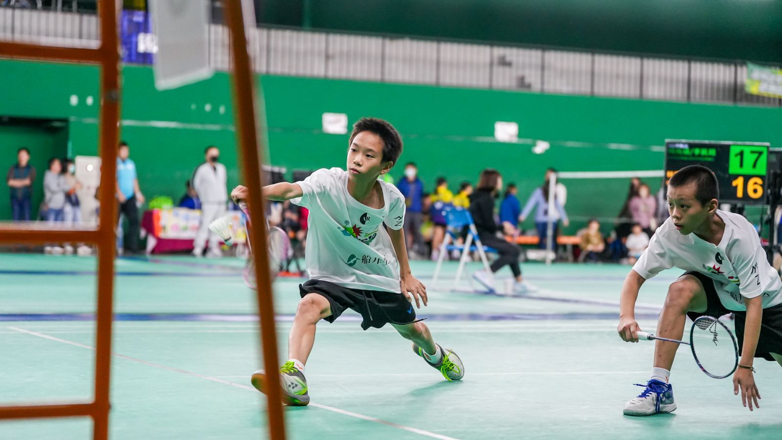 兩個年輕人正在球場上打羽球。