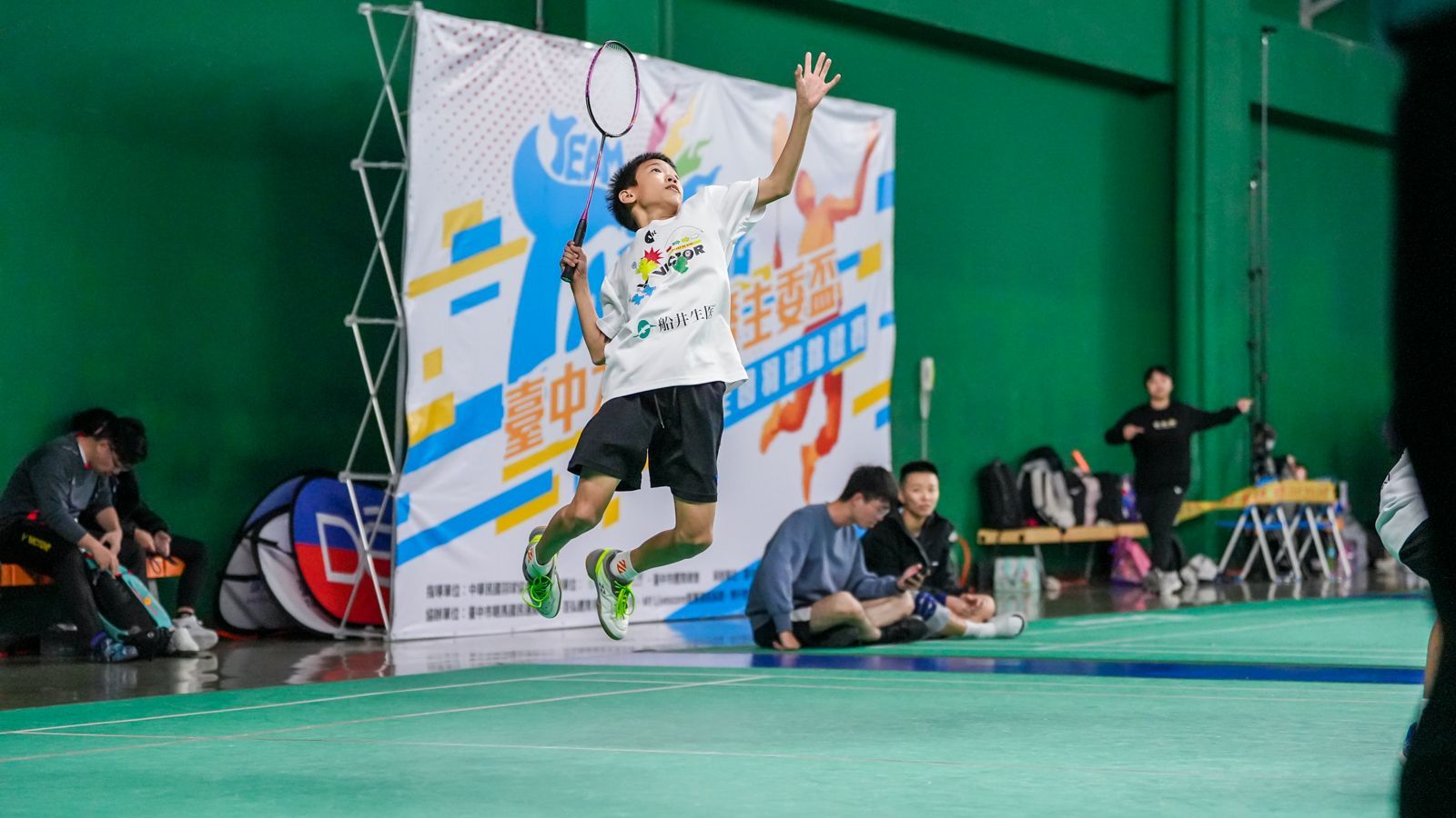 一名男子在球場上打羽球時在空中跳躍。