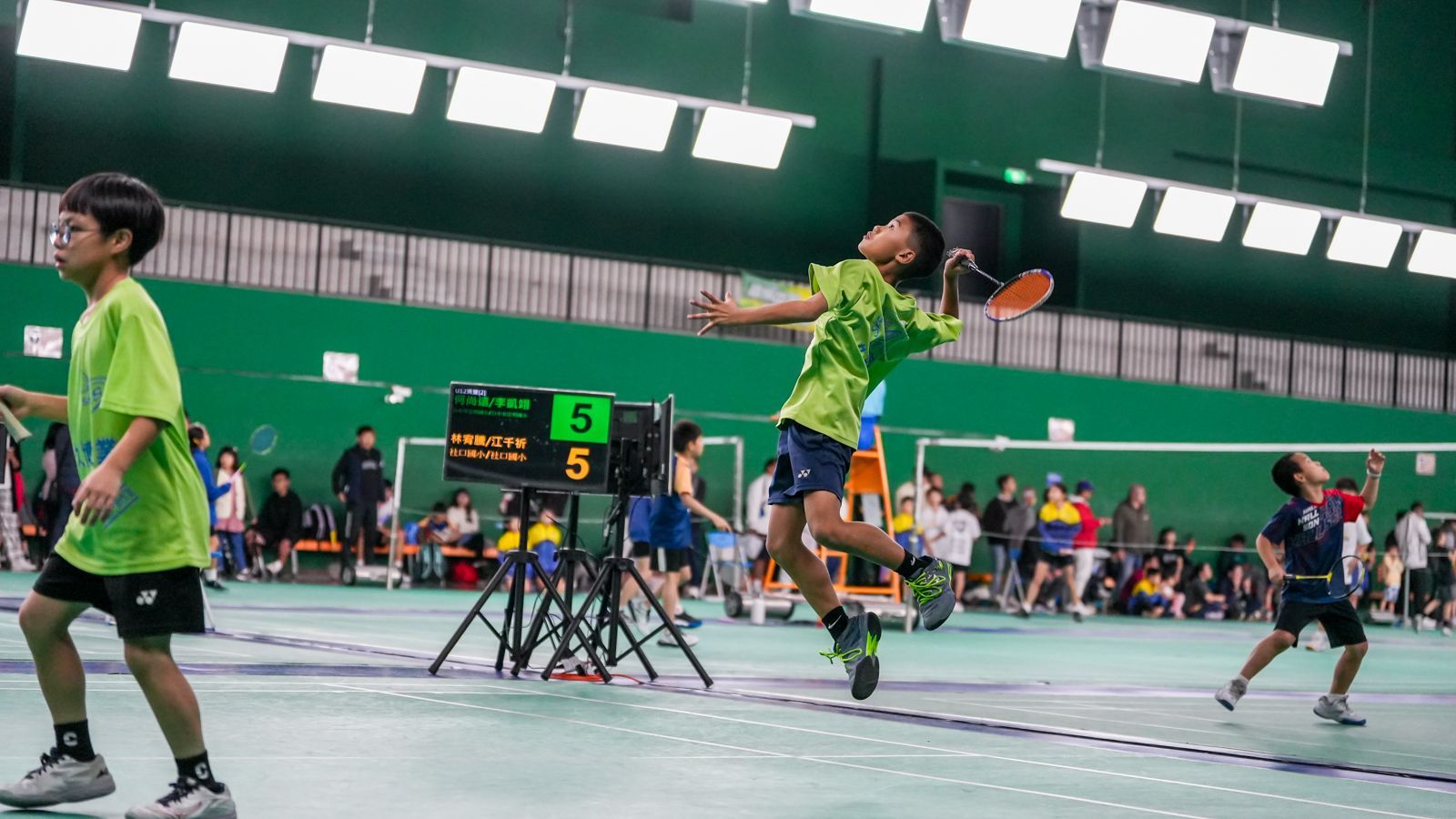 一群小男孩正在健身房裡打羽毛球。