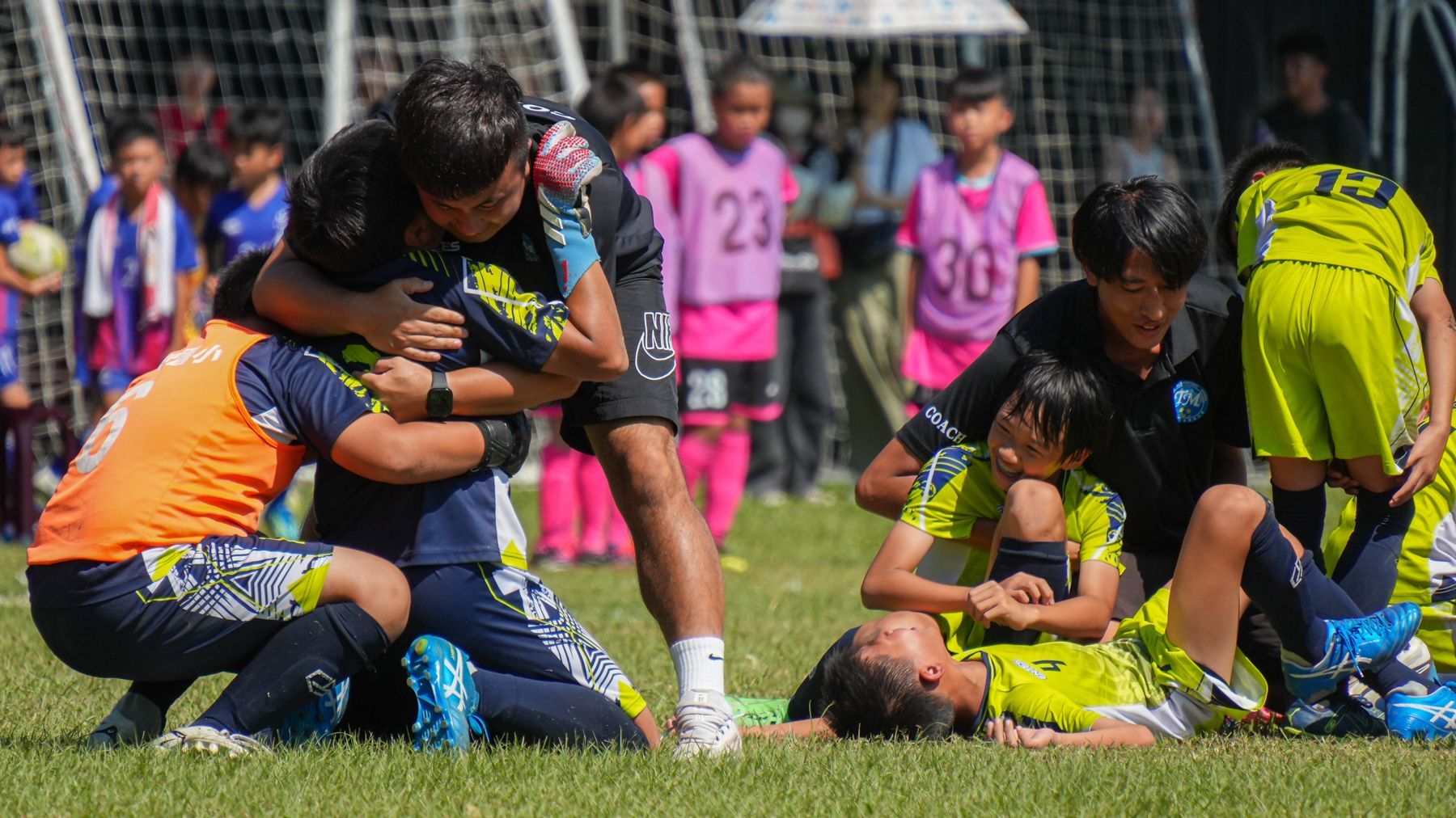 一群小男孩在足球場上互相擁抱。