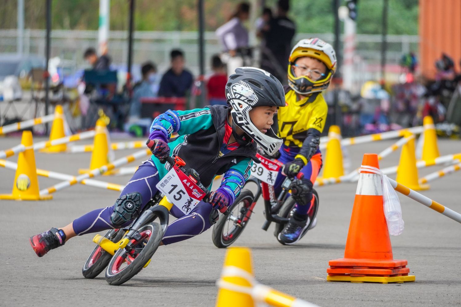 兩個小男孩正在跑道上騎腳踏車。