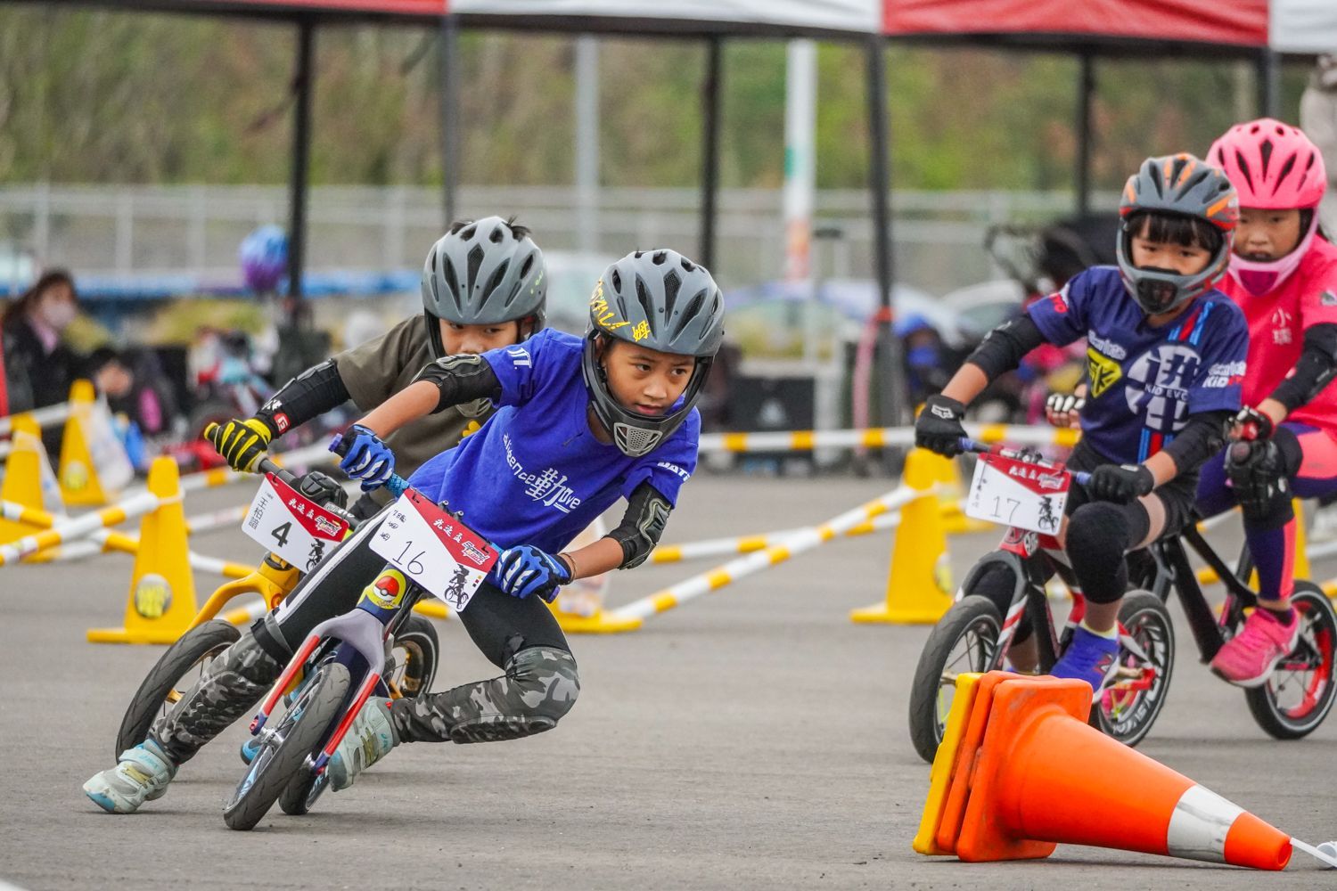 一群小孩子正在路上騎腳踏車。