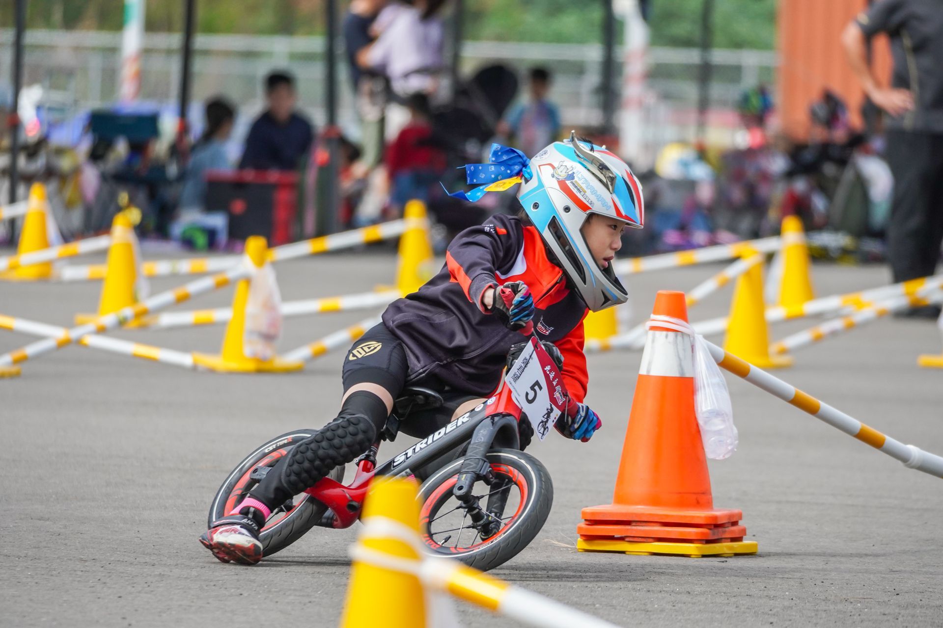 一個小男孩騎著平衡車穿過交通錐。