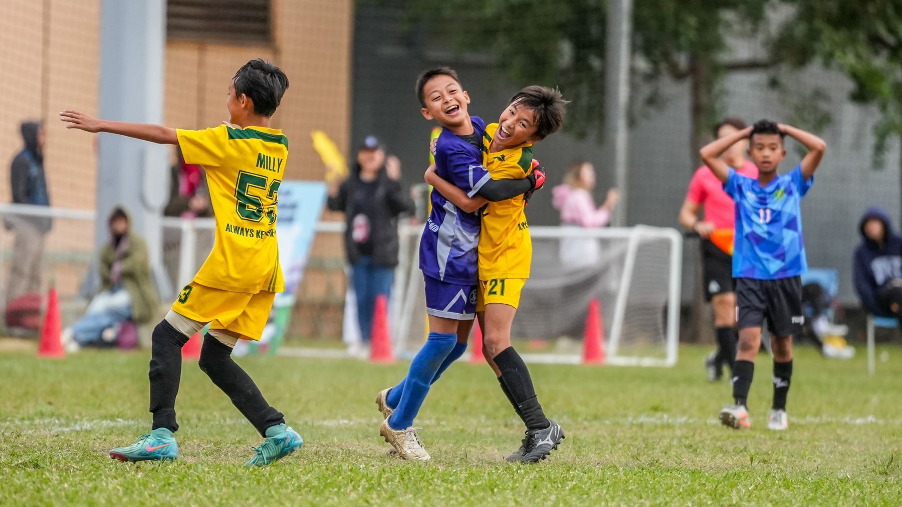 一群小男孩正在操場上踢足球。
