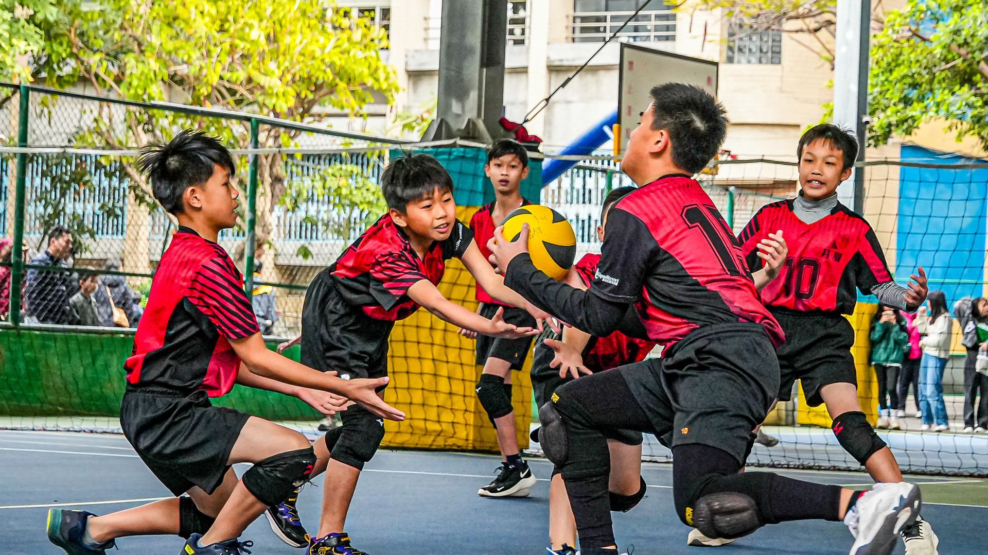 一群小男孩正在球場上打排球。