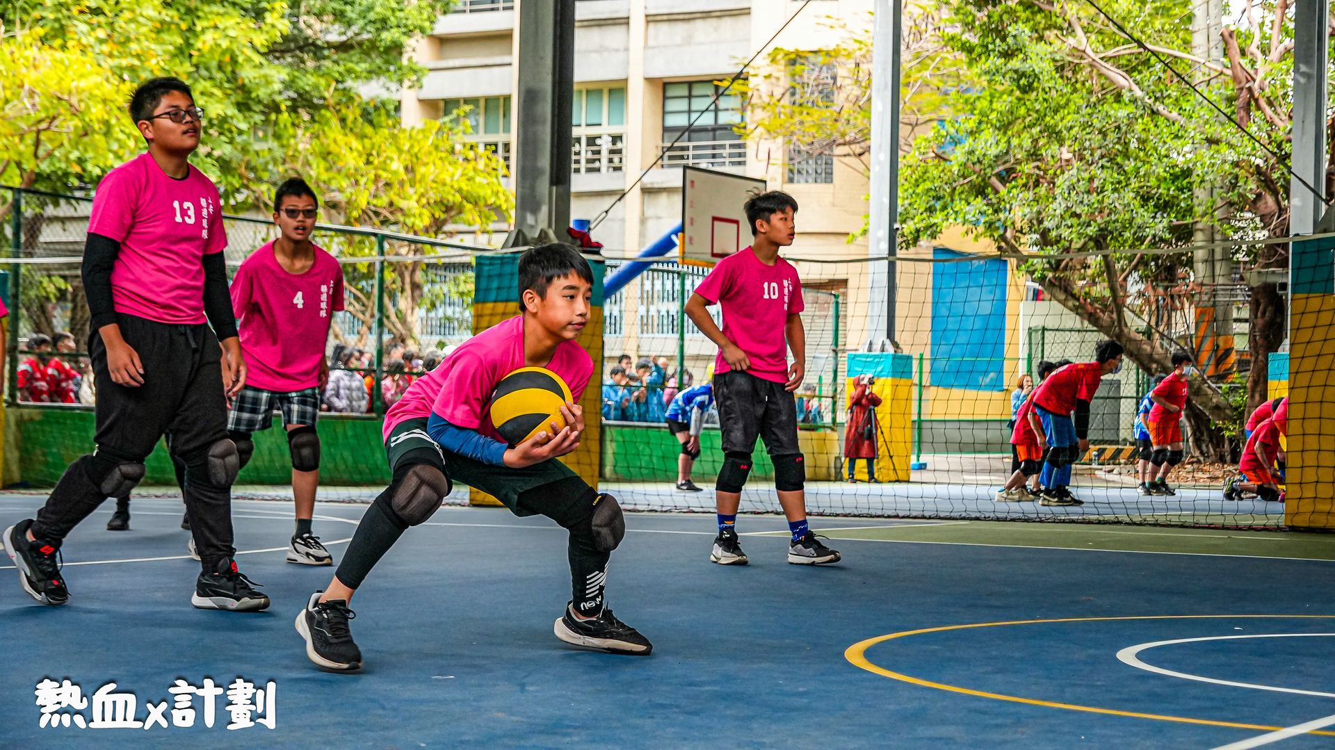 一群小男孩正在球場上打籃球。