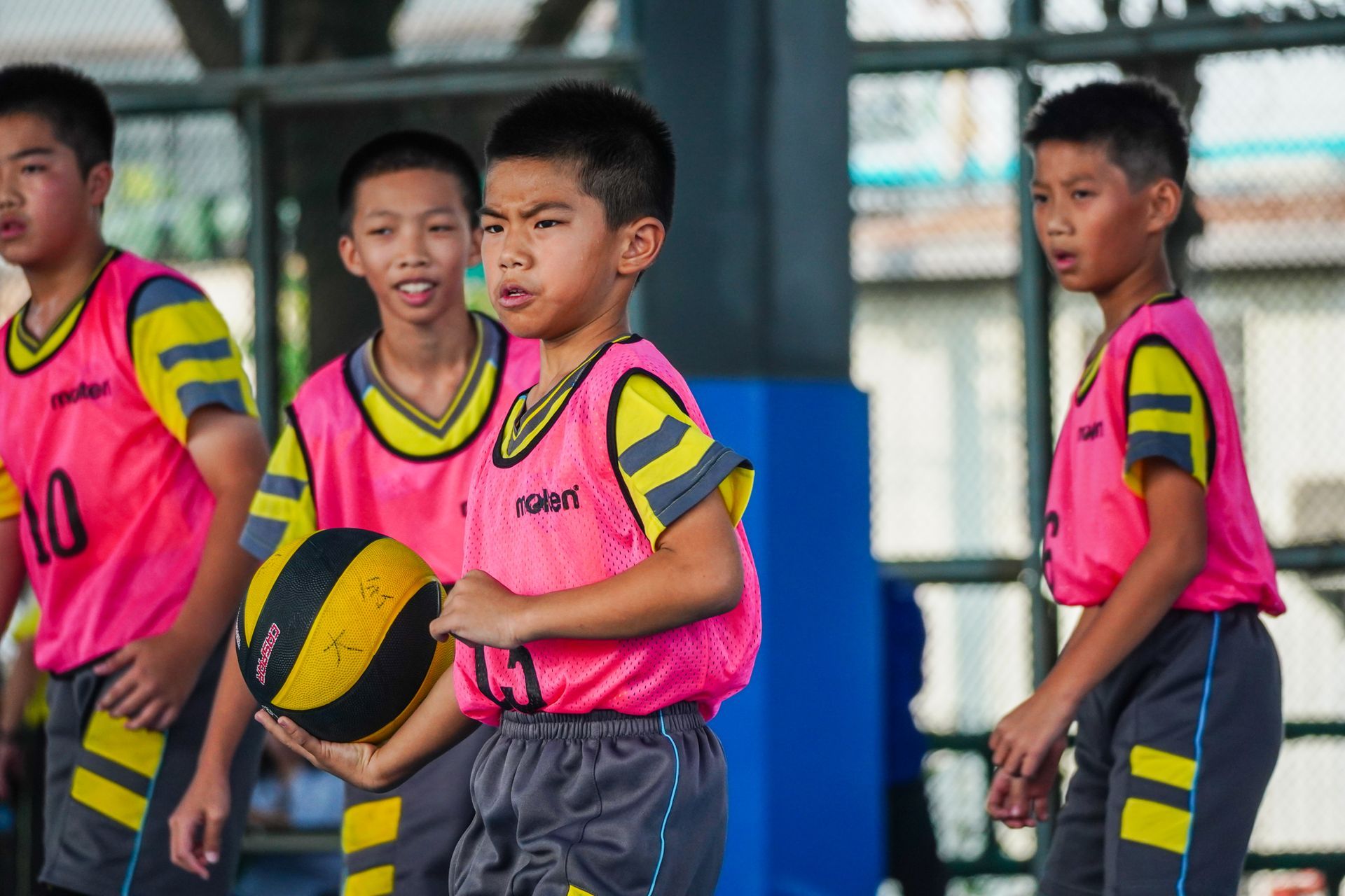 一群小男孩正在球場上打籃球。