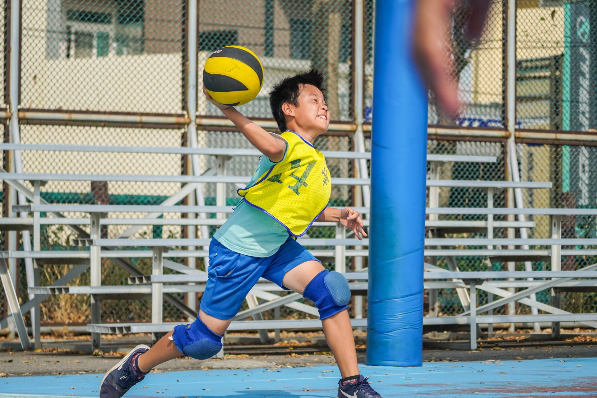 一個小男孩正在球場上打排球。