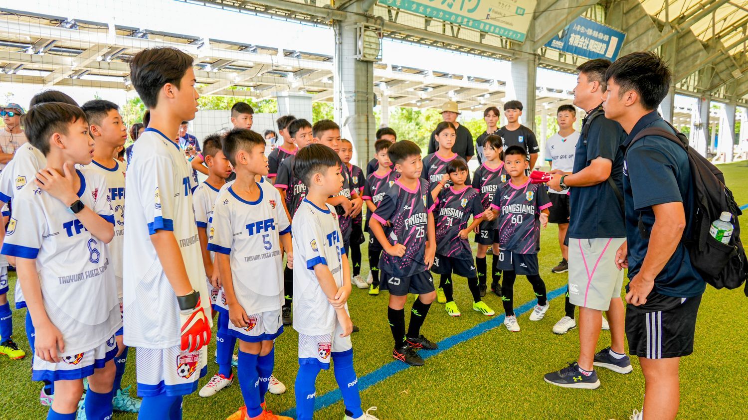 一群小男孩在足球場上並肩站立。