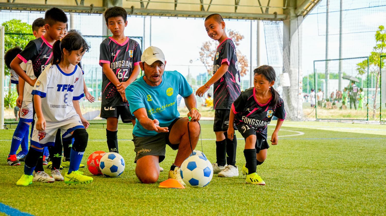 一群小男孩正在和教練一起踢足球。