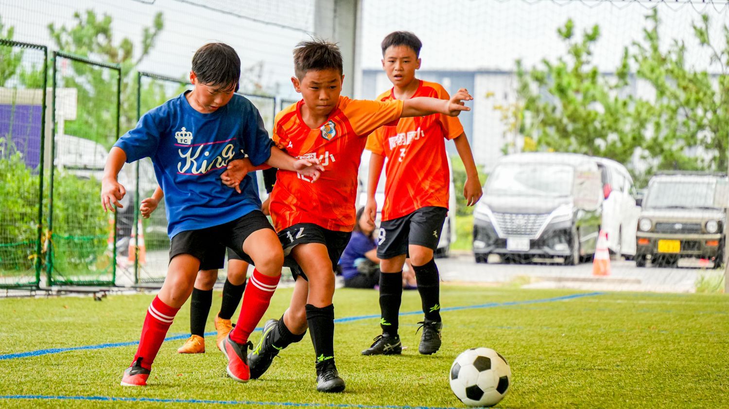 一群小男孩正在操場上踢足球。