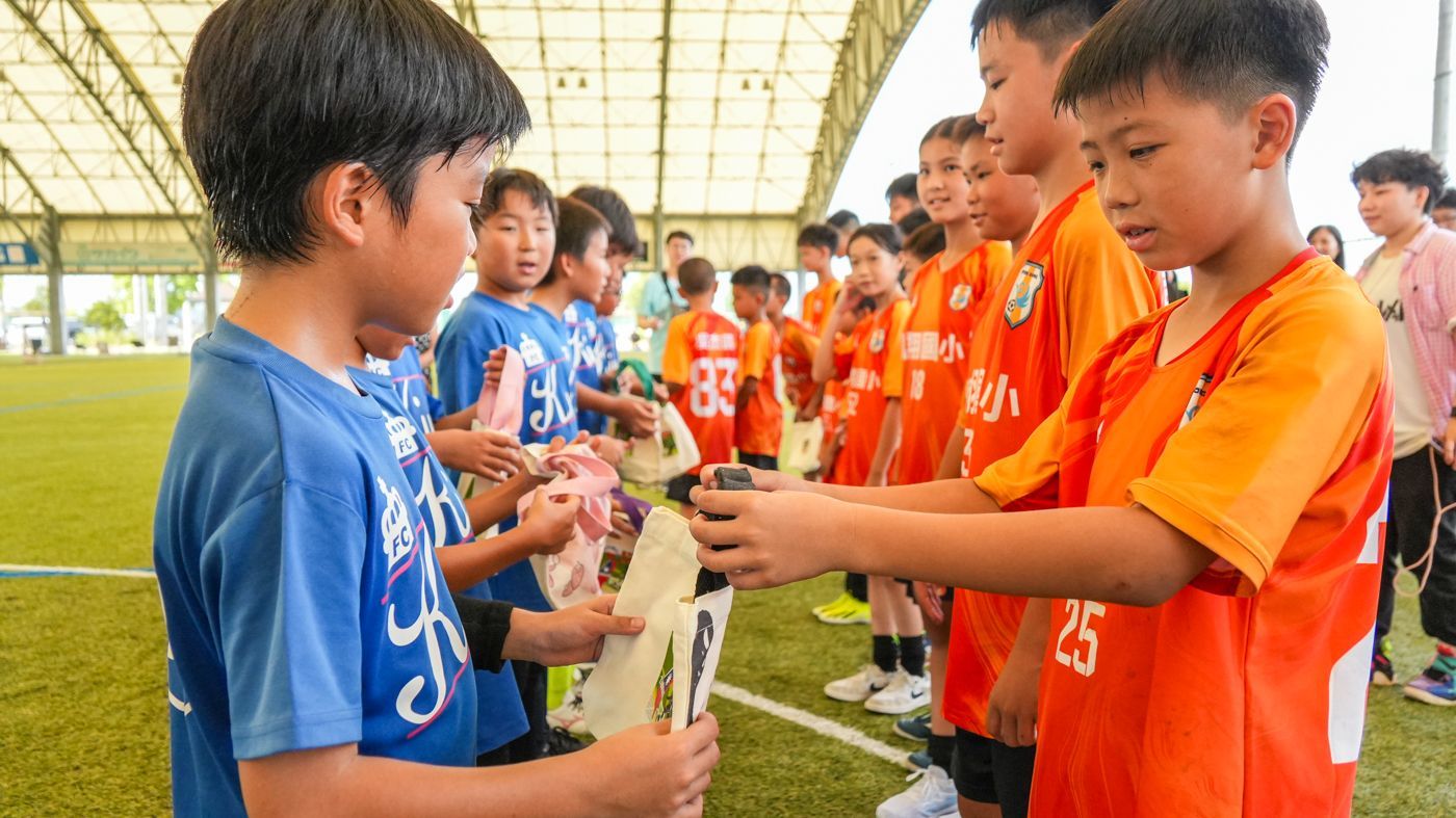 一群小男孩在足球場上握手。