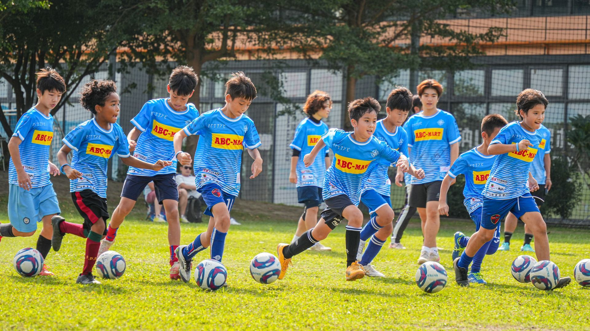 一群小男孩正在操場上踢足球。