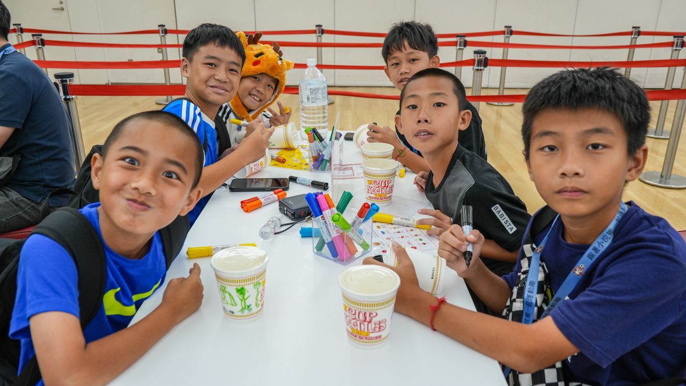 一群小男孩端著咖啡坐在桌前。