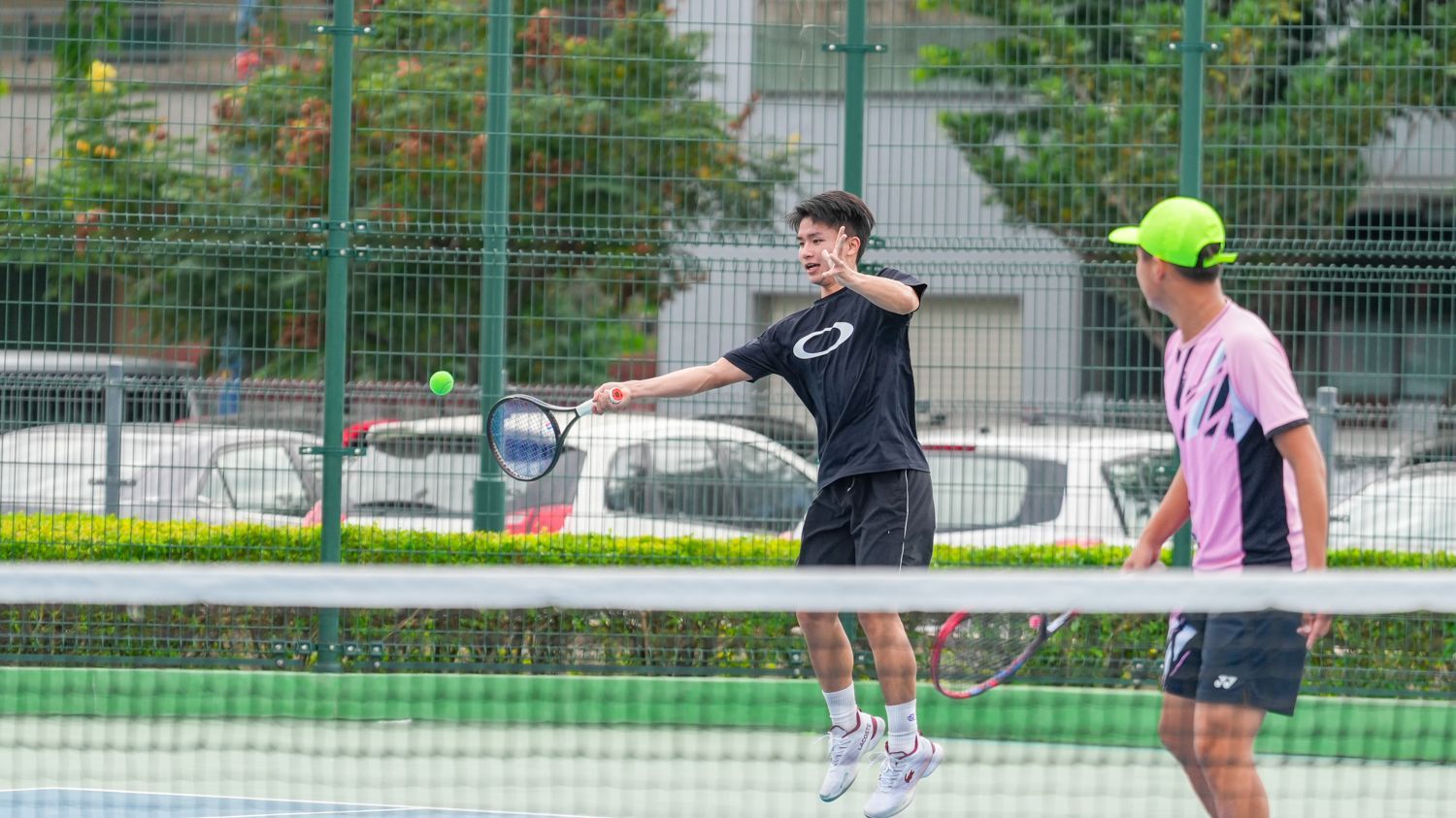 兩個男人正在網球場上打網球。