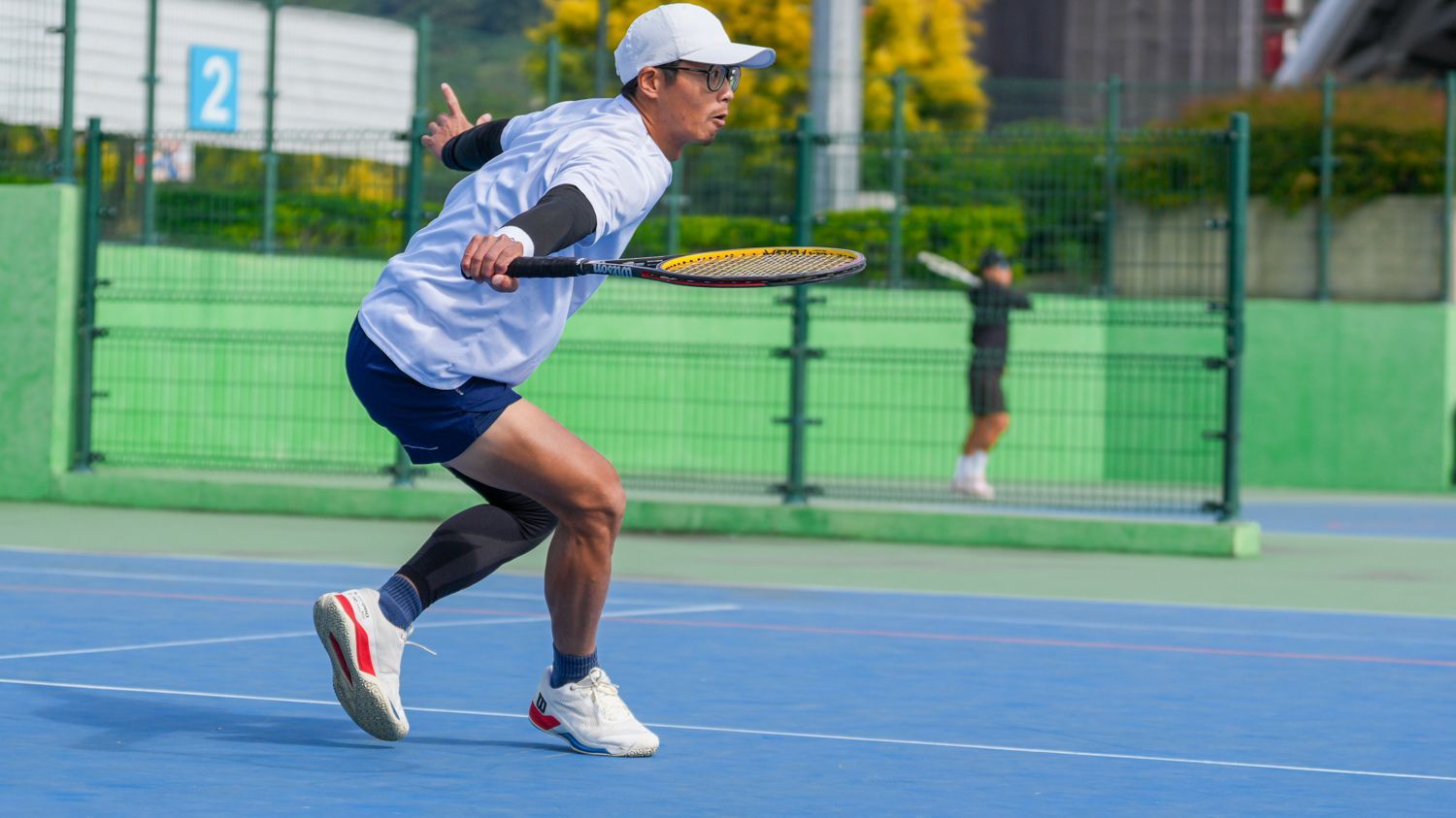 一名男子在網球場上拿著網球拍。