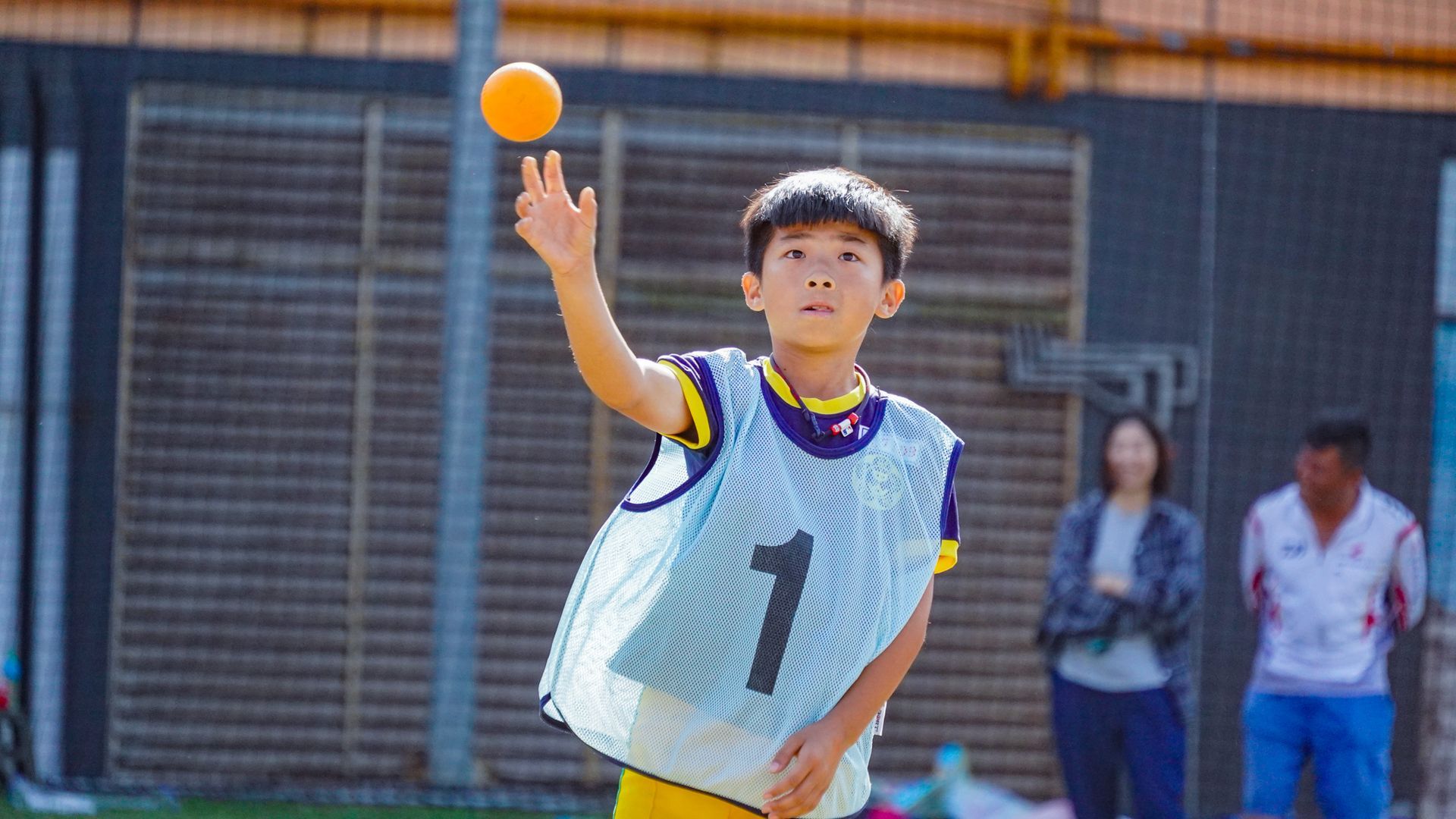 一個小男孩正在向空中丟球。