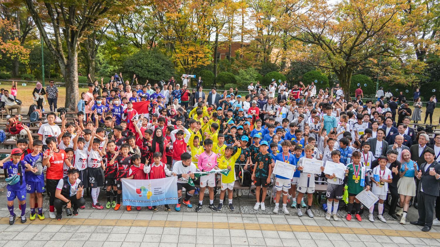 一大群人正在公園裡擺姿勢拍照。