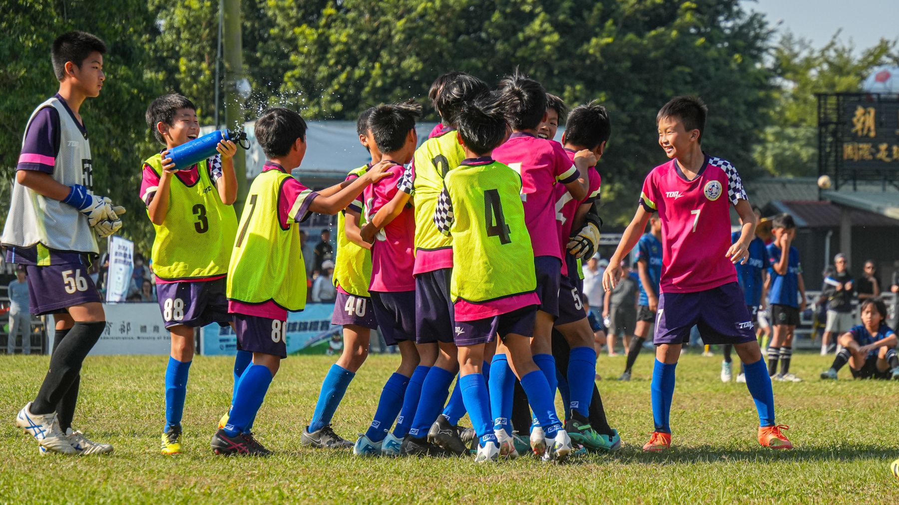 一群小男孩正在操場上踢足球。