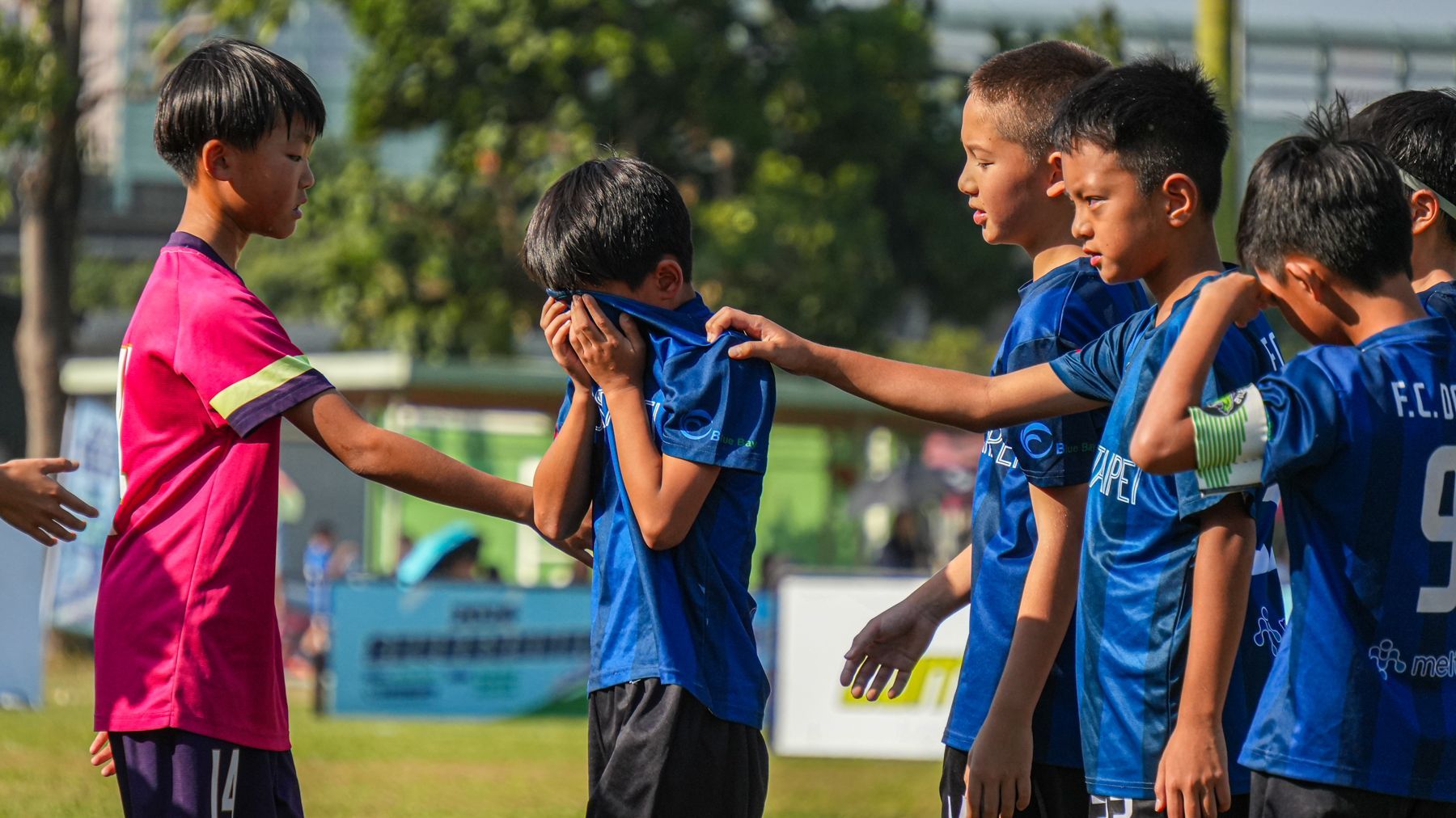 一群小男孩正在操場上踢足球。