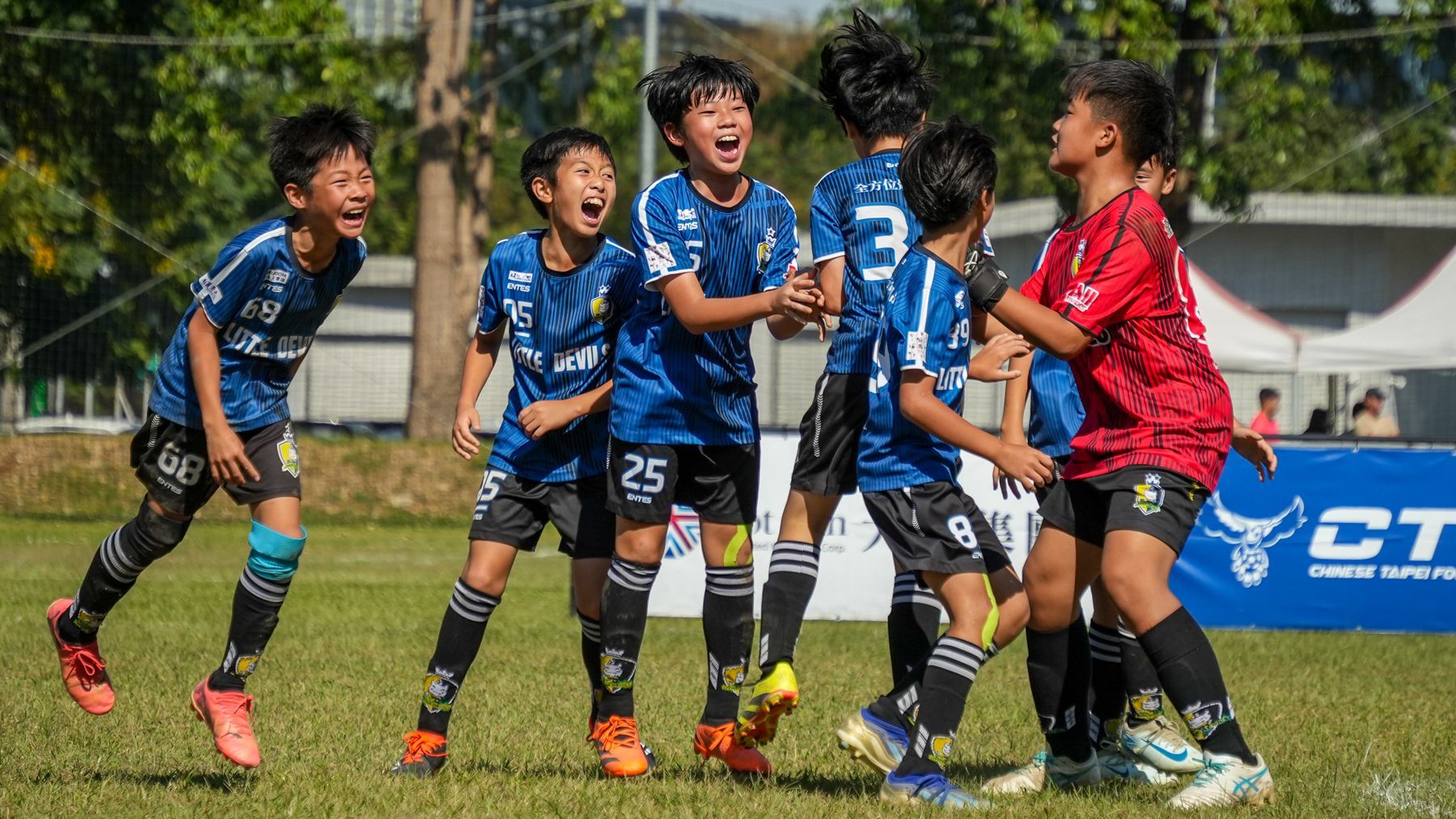一群小男孩正在操場上踢足球。
