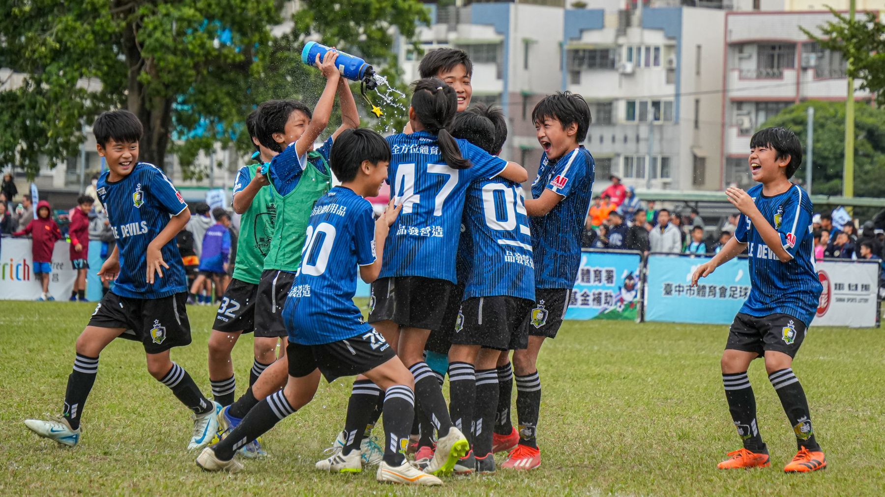 一個小男孩正在綠色的球場上打羽球。