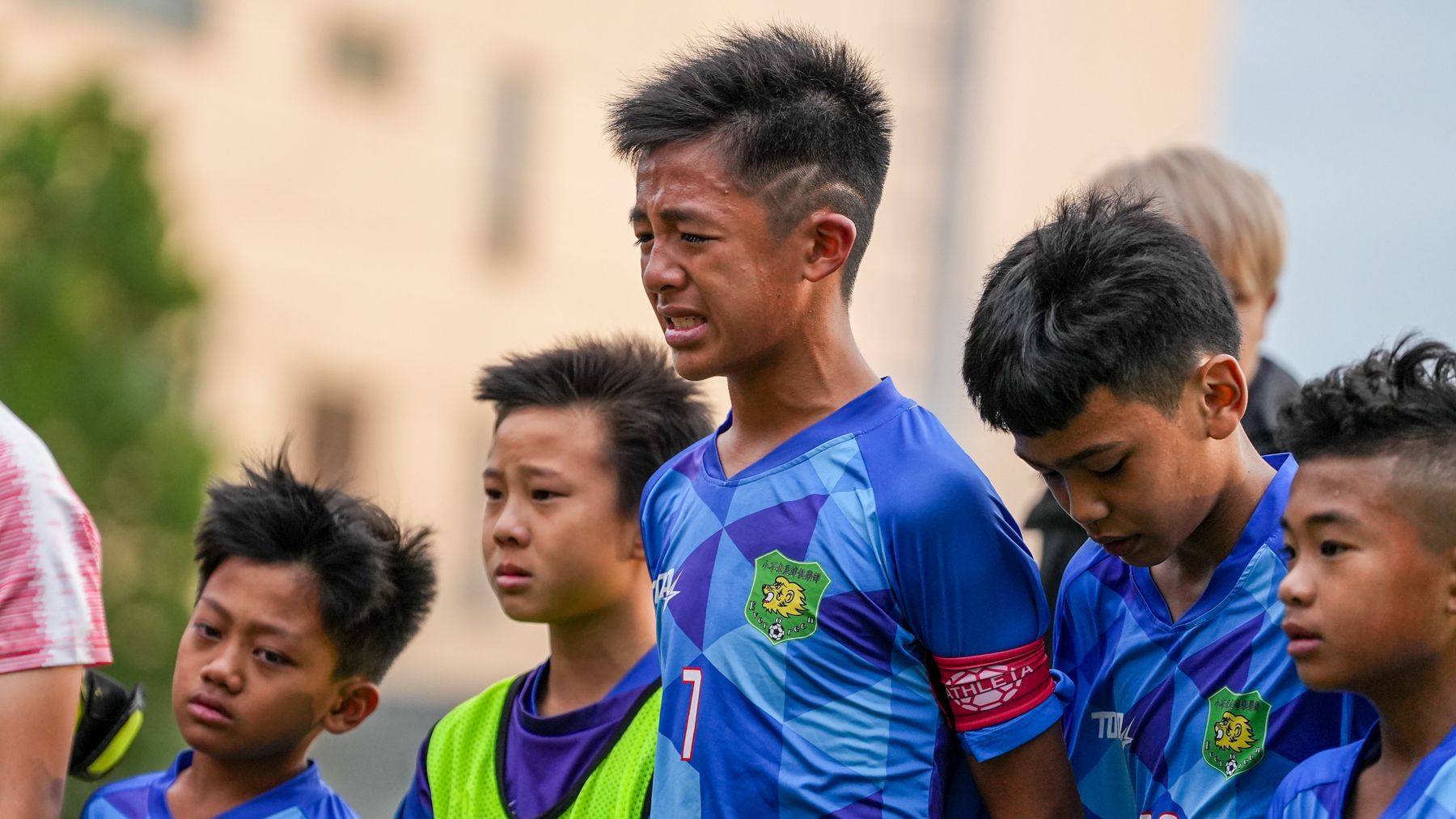 一群小男孩在足球場上並肩站立。